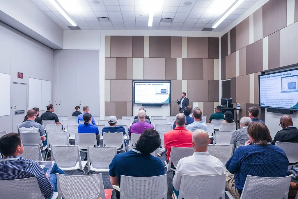 Conference room with a speaker giving a presentation to an audience.