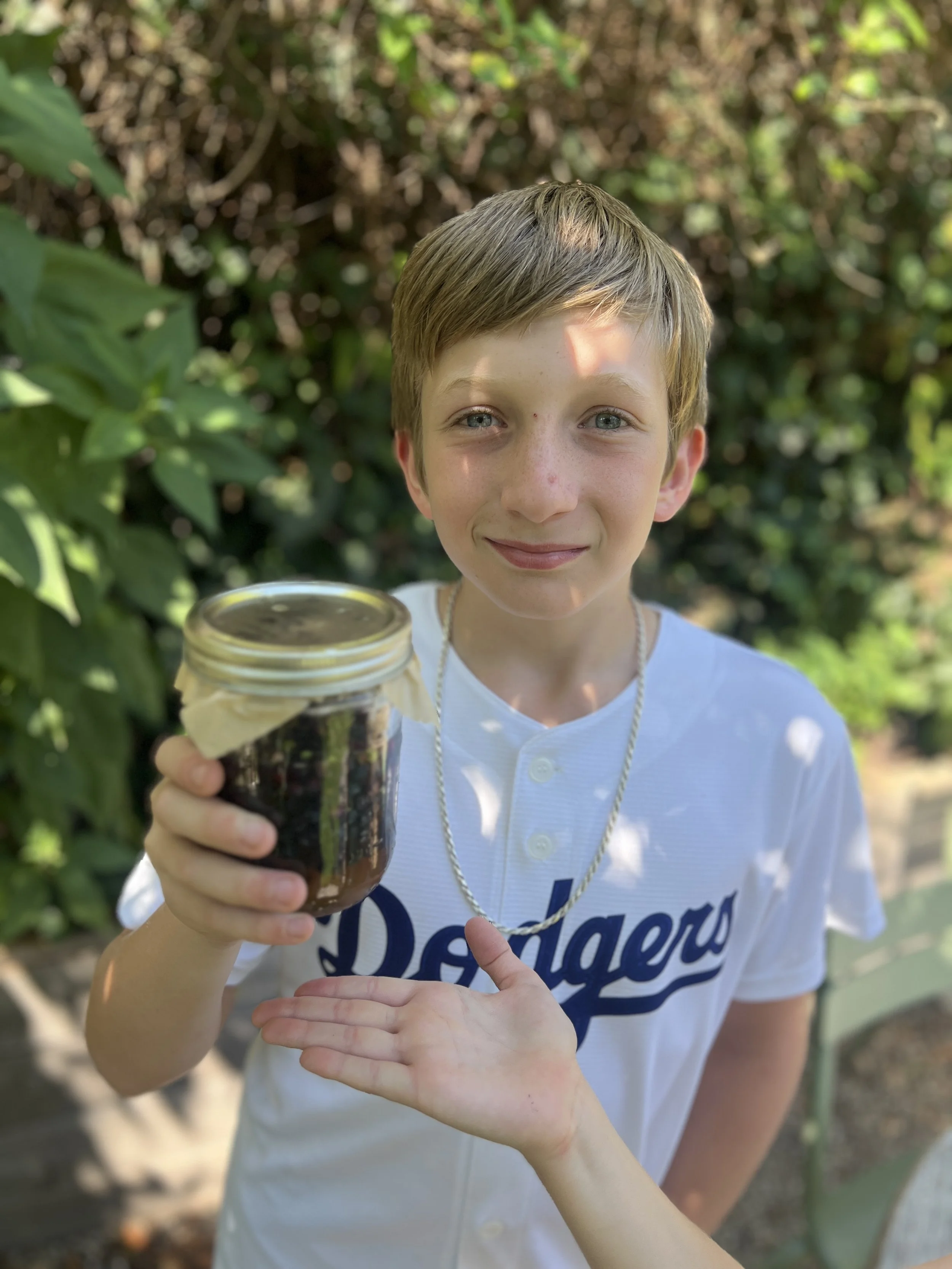 Student with a jar of wild blueberry tincture. 