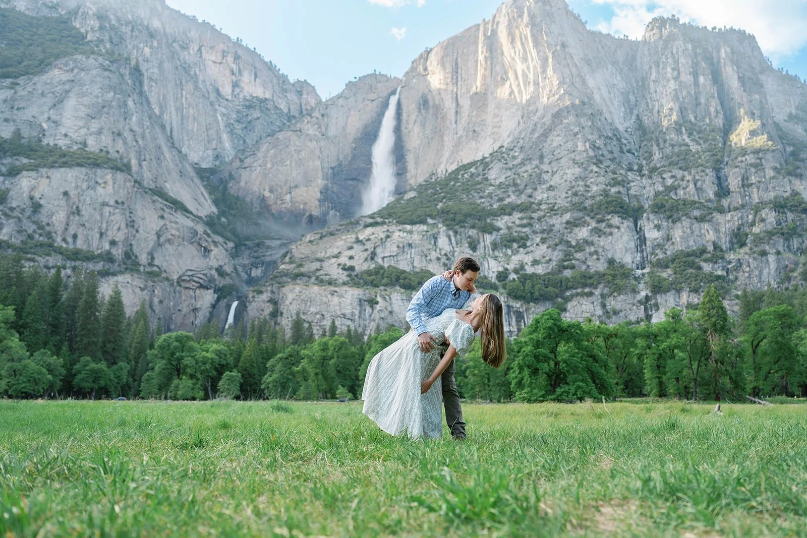 Man dips woman in dramatic pose in Yosemite's El Cap Meadow