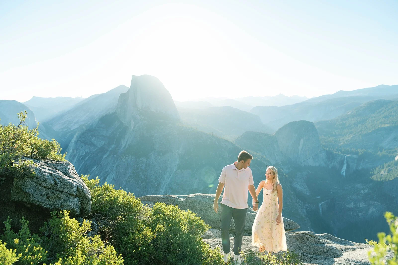 Man and woman hold hands after their Yosemite proposal at Glacier Point