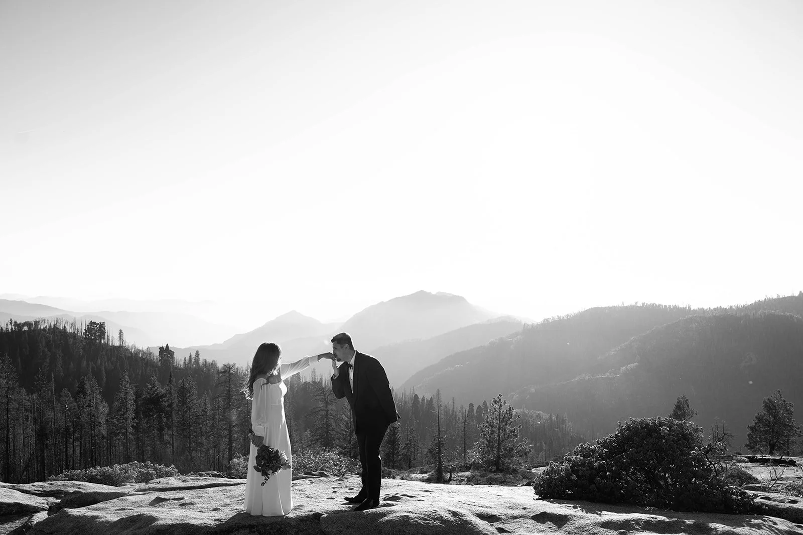 Man kisses woman's hand at their Beetle Rock elopement ceremony