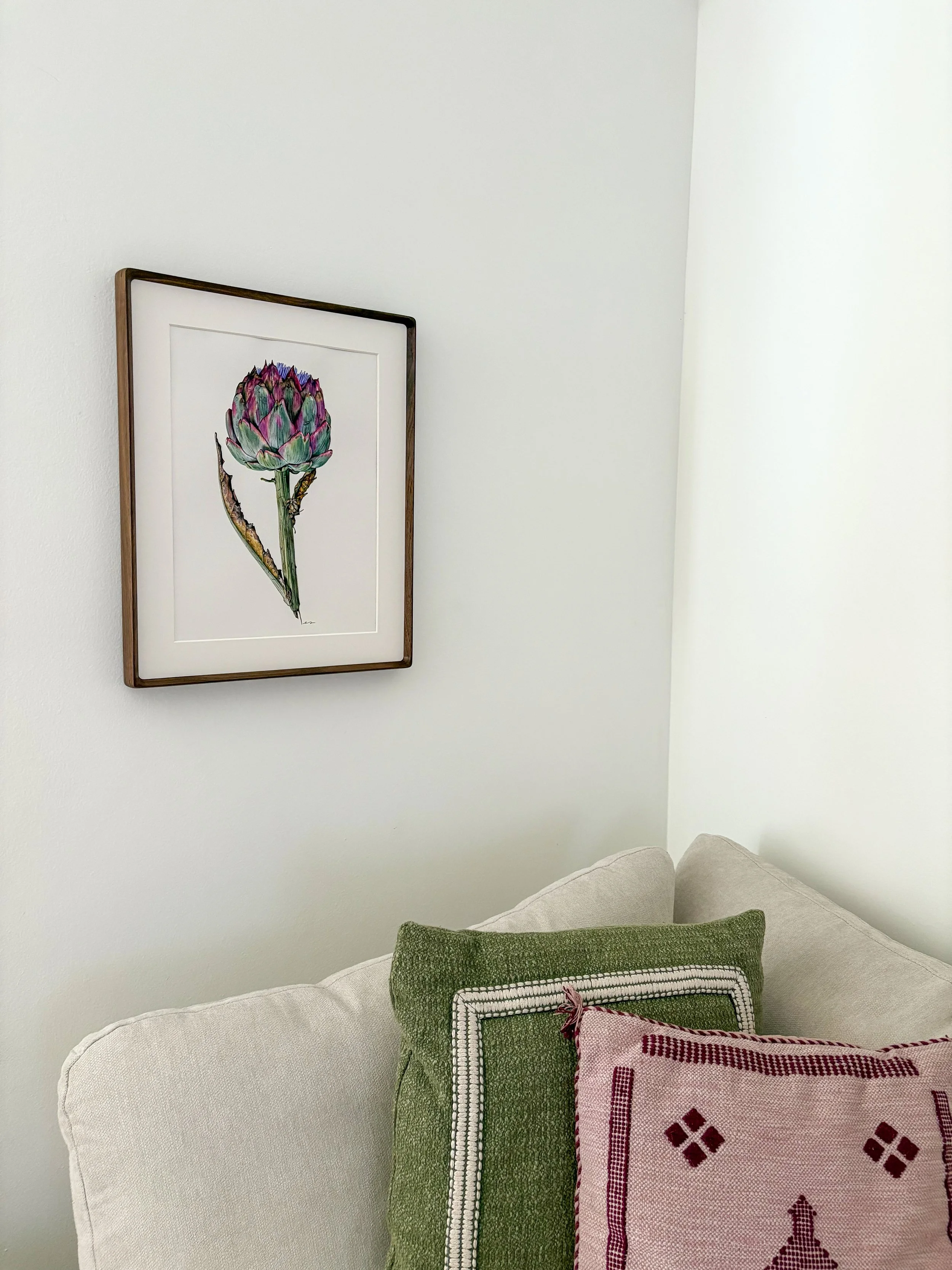 Original framed watercolor painting of a full stem artichoke in sage green and deep purple with a lilac flower at the crown, in a dark walnut wood frame