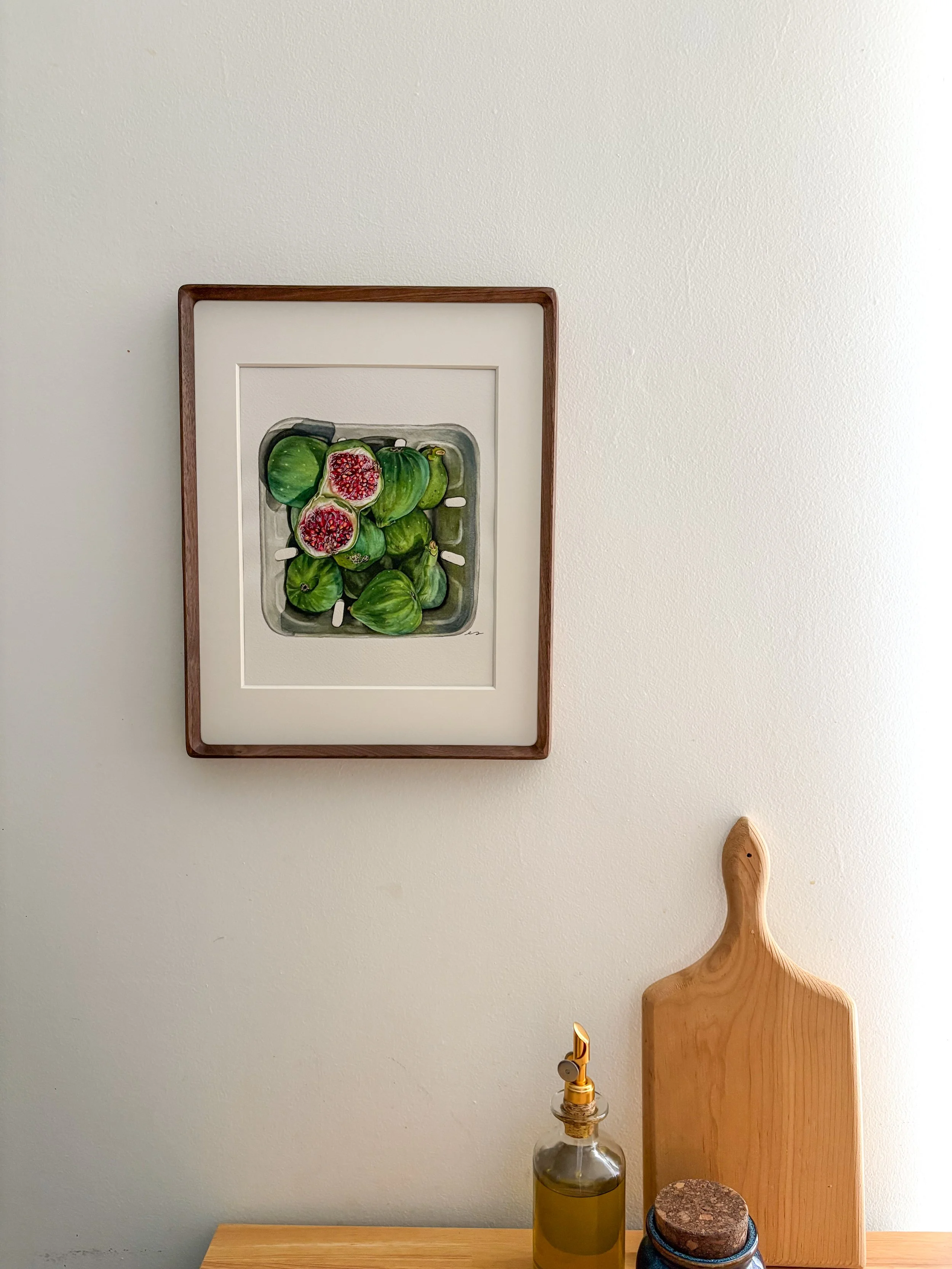 Original framed watercolor painting of green figs piled in a market container, two sliced open showing deep red centers, in a dark walnut wood frame