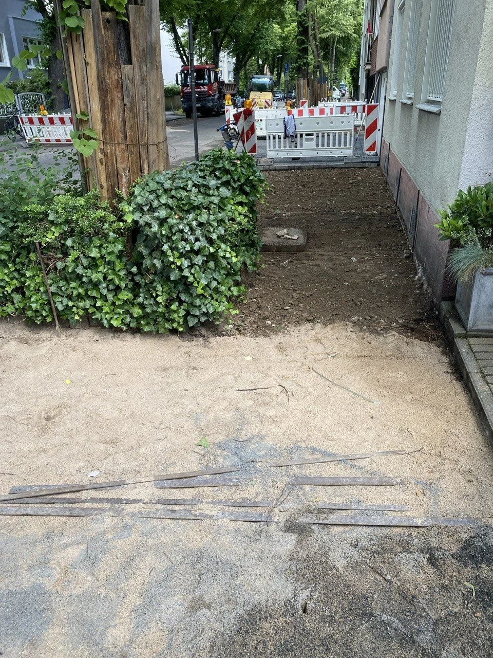 Straßensperrung bei Bauarbeiten, mit Absperrungen und Baugeräten im Hintergrund.