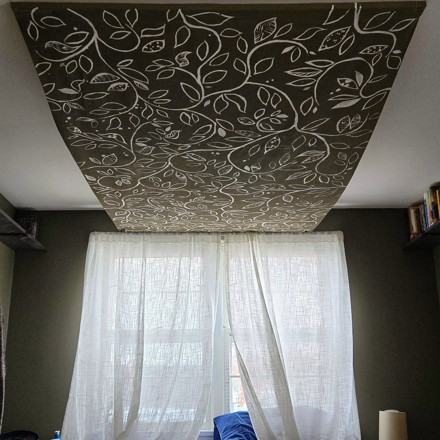 We painted our bedroom a beautiful dark green with light curtains and white ceiling. The ceiling was a bit too light for the cozy cave we wanted our bedroom to be.

I didn't know about the practicality of a ceiling mural, or committing to painting th
