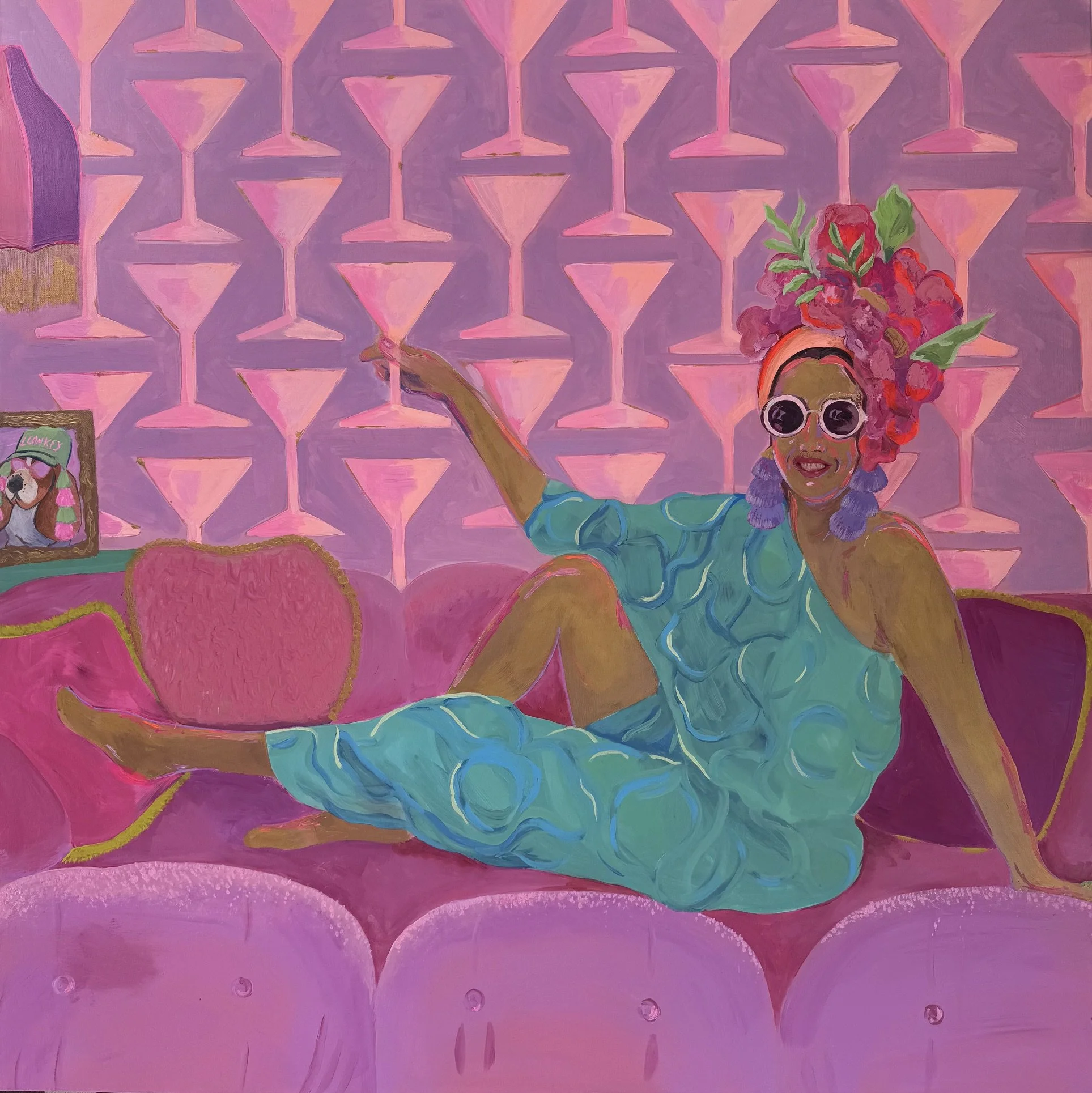 A colorful painting featuring a woman with an elaborate pink flower headpiece, large round glasses, and a bright smile. The background consists of a pink and purple geometric pattern resembling interconnected hourglasses or diamonds. The woman is holding a green object in her hand, and various pink and purple accents are present throughout the image.