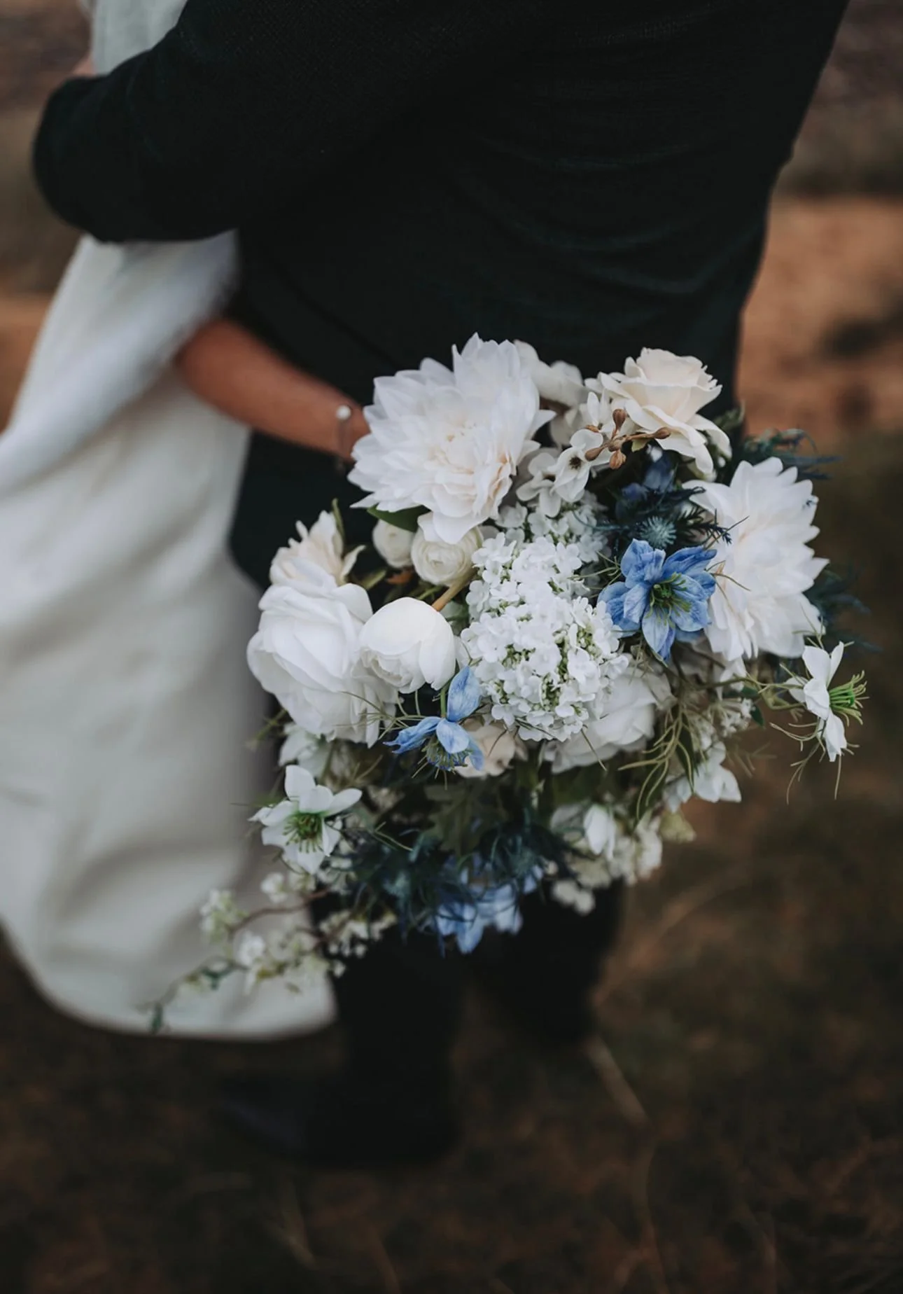 Bride holding a luxury white and blue wedding bouquet from Sheer Blooms' wedding flower hire collection.