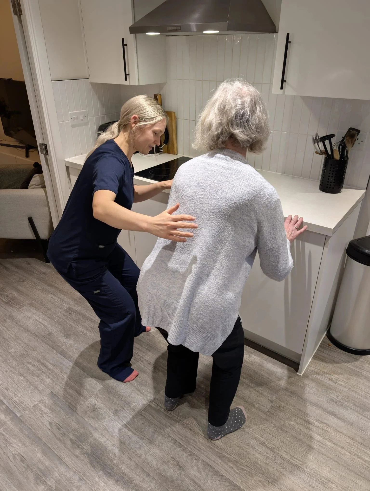 Salveo Forma physiotherapist supporting an older woman with balance and walking in her kitchen