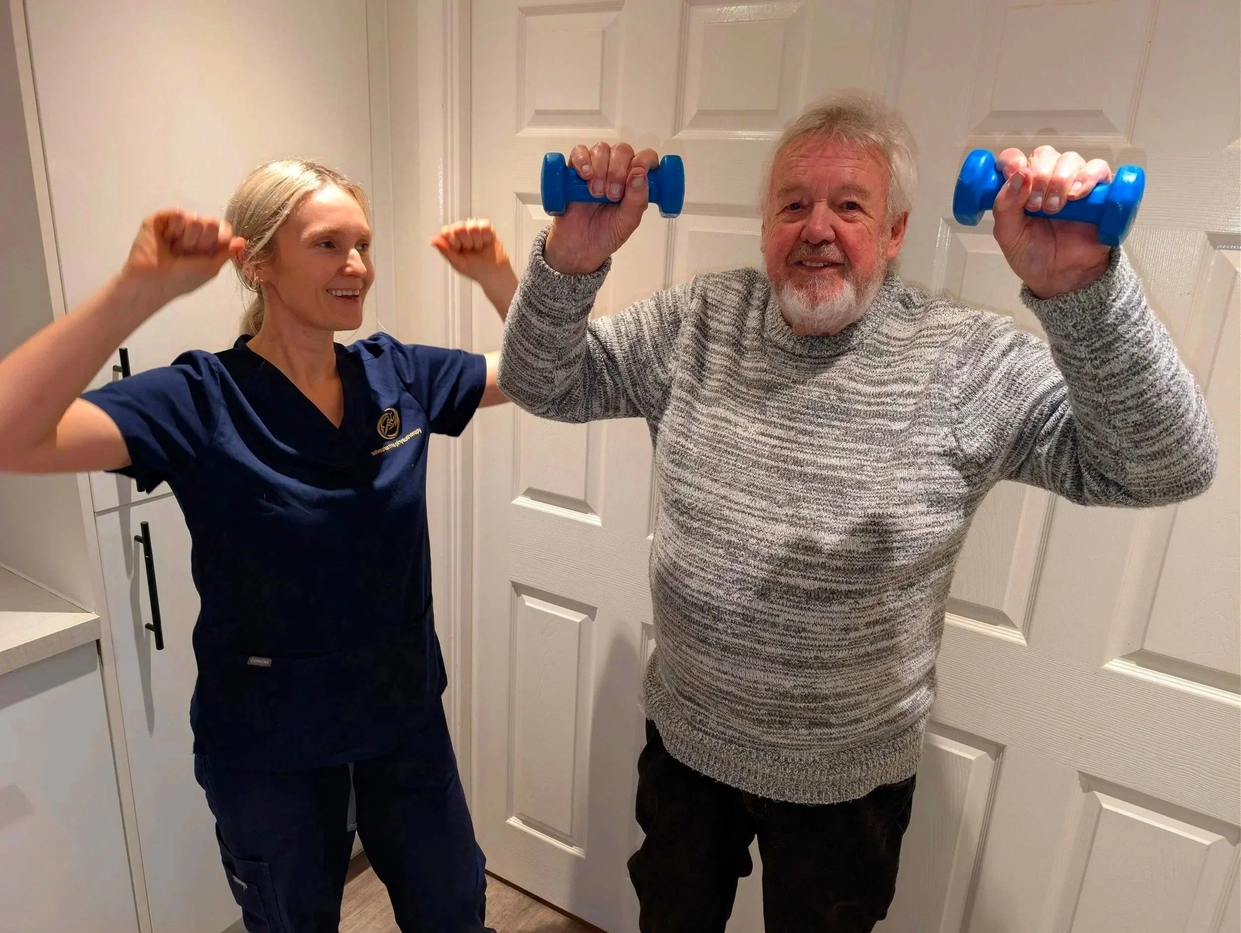Salveo Forma physiotherapist leading an arm-strengthening exercise with an older man at home
