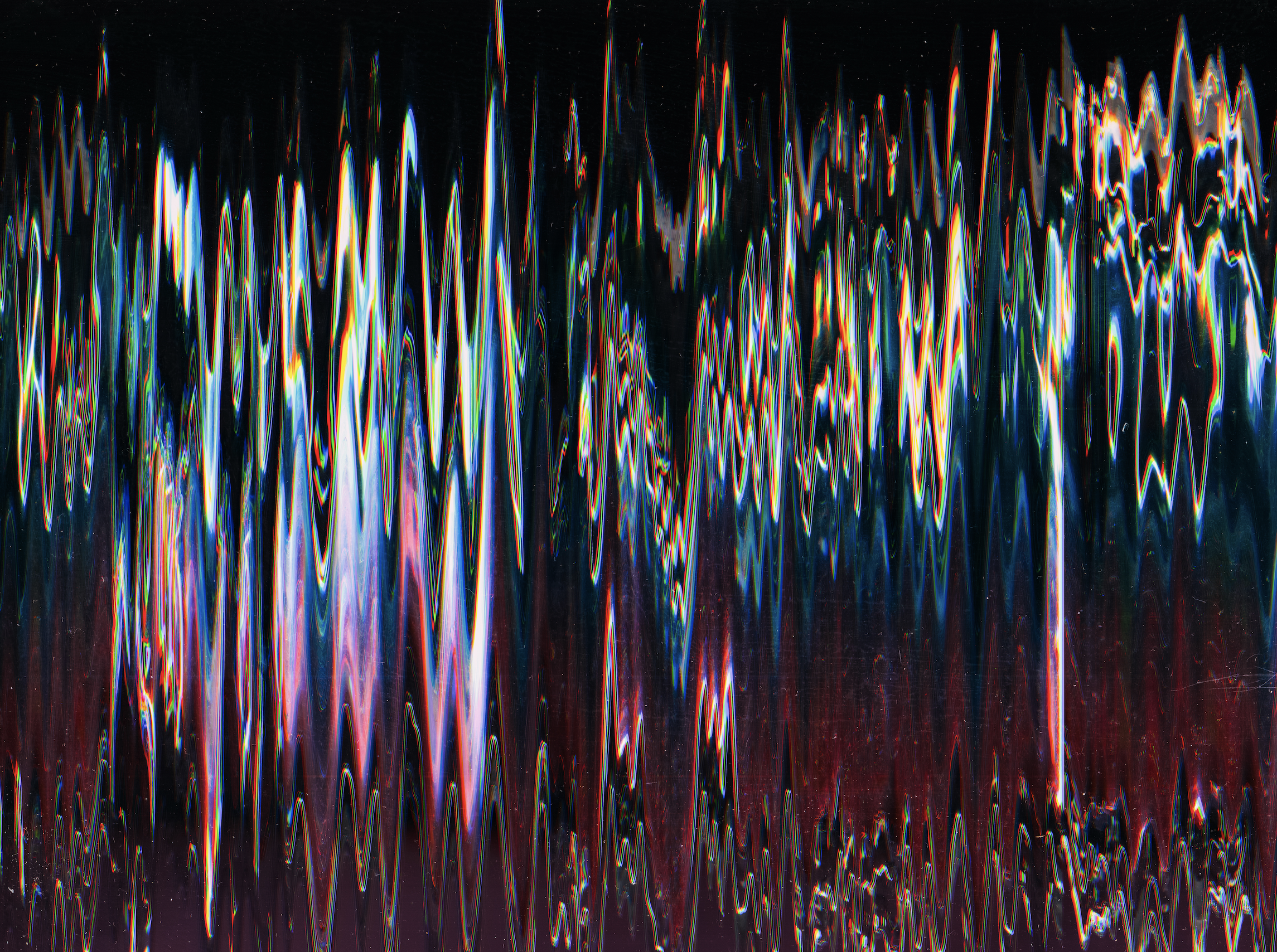 Colorful light streaks and reflections on a dark surface, creating an abstract, vibrant pattern.