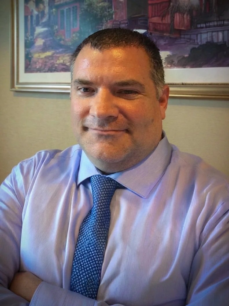 Silhouette of a person in front of a bright blue circle on a black background.