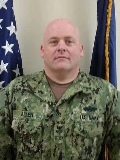 Silhouette of a person against a bright blue circle on a black background.