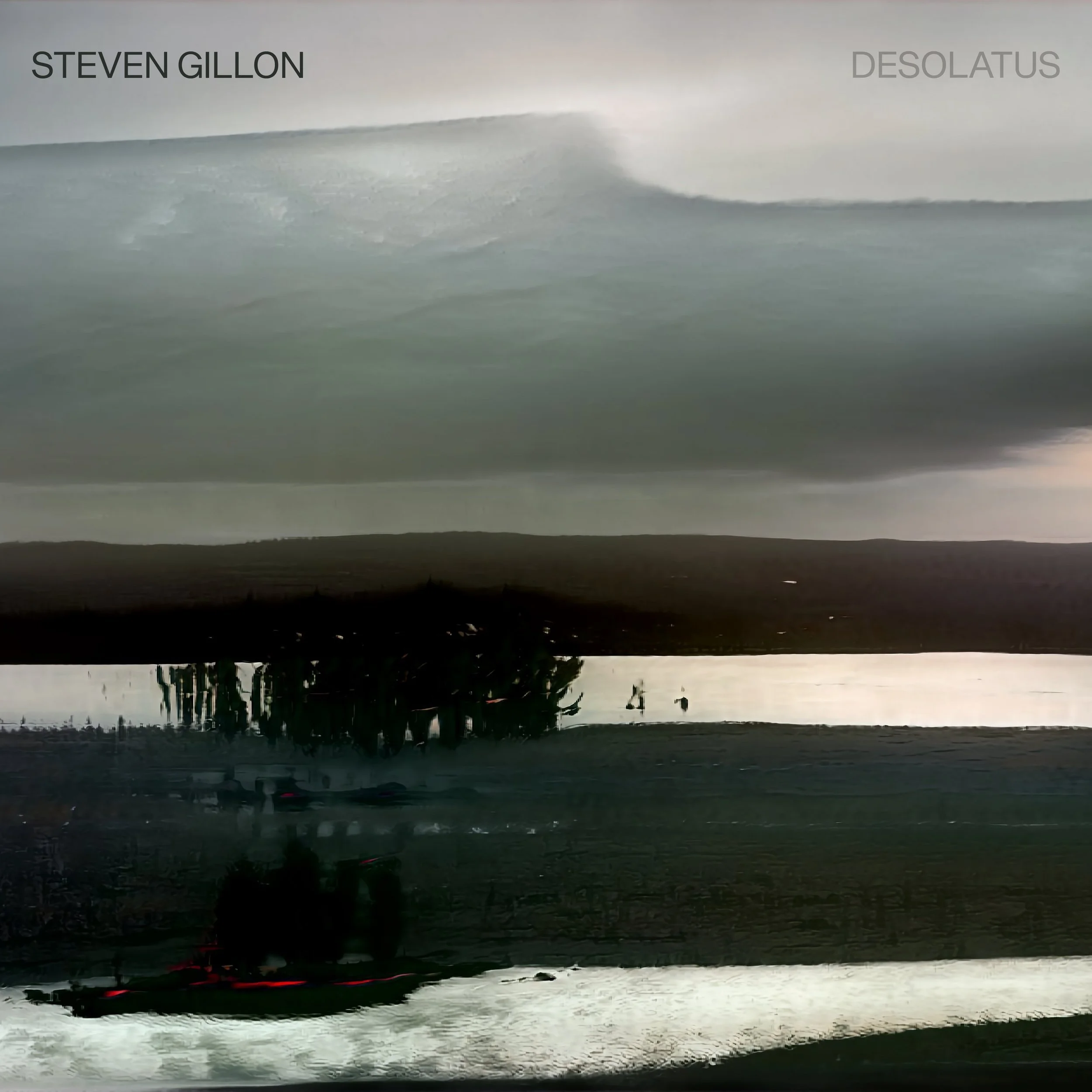 A landscape scene with a body of water and a distant shoreline. The sky appears overcast and cloudy with reflections on the water's surface. The image has a dark, moody tone.