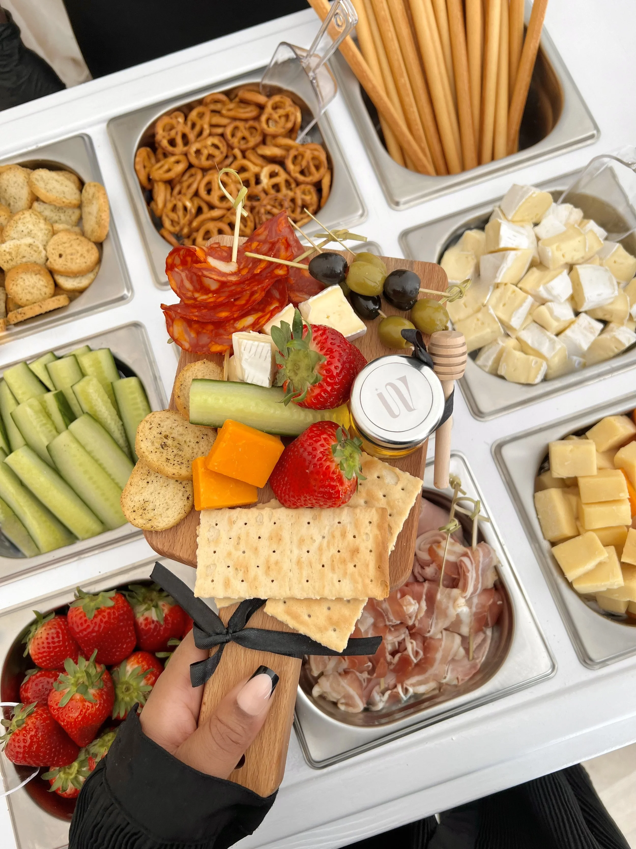 A variety of cheeses arranged on the charcuterie cart, with different textures and rinds.