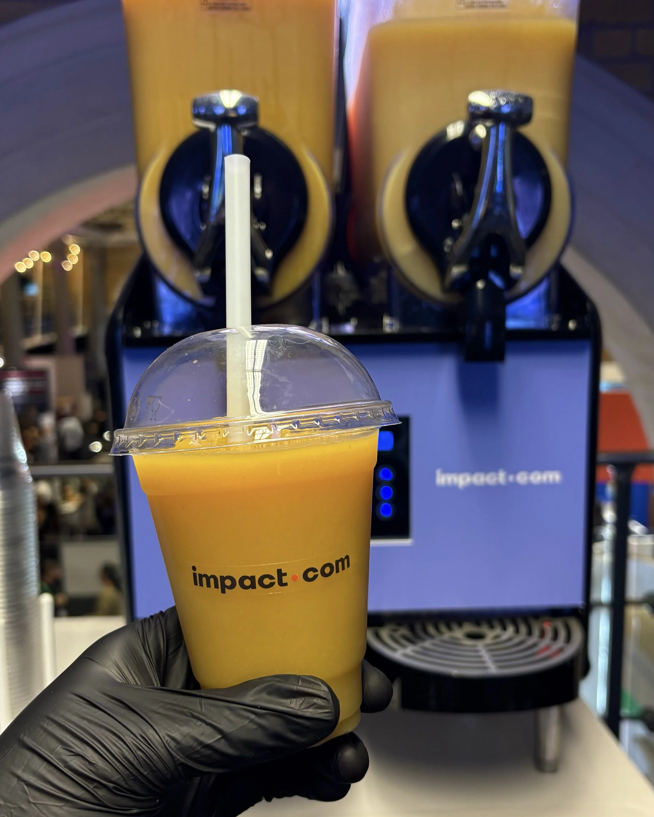 Fruity natural slush served in custom stickered cups from the Moments Event Hire slush cart for impact.com, London