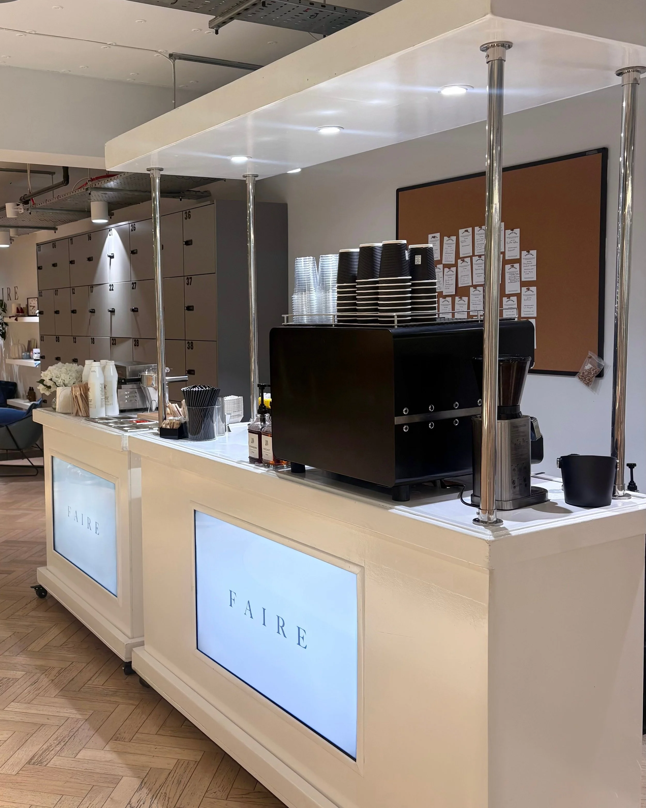 Two Faire branded coffee carts with espresso machines and branded screens at a corporate office event