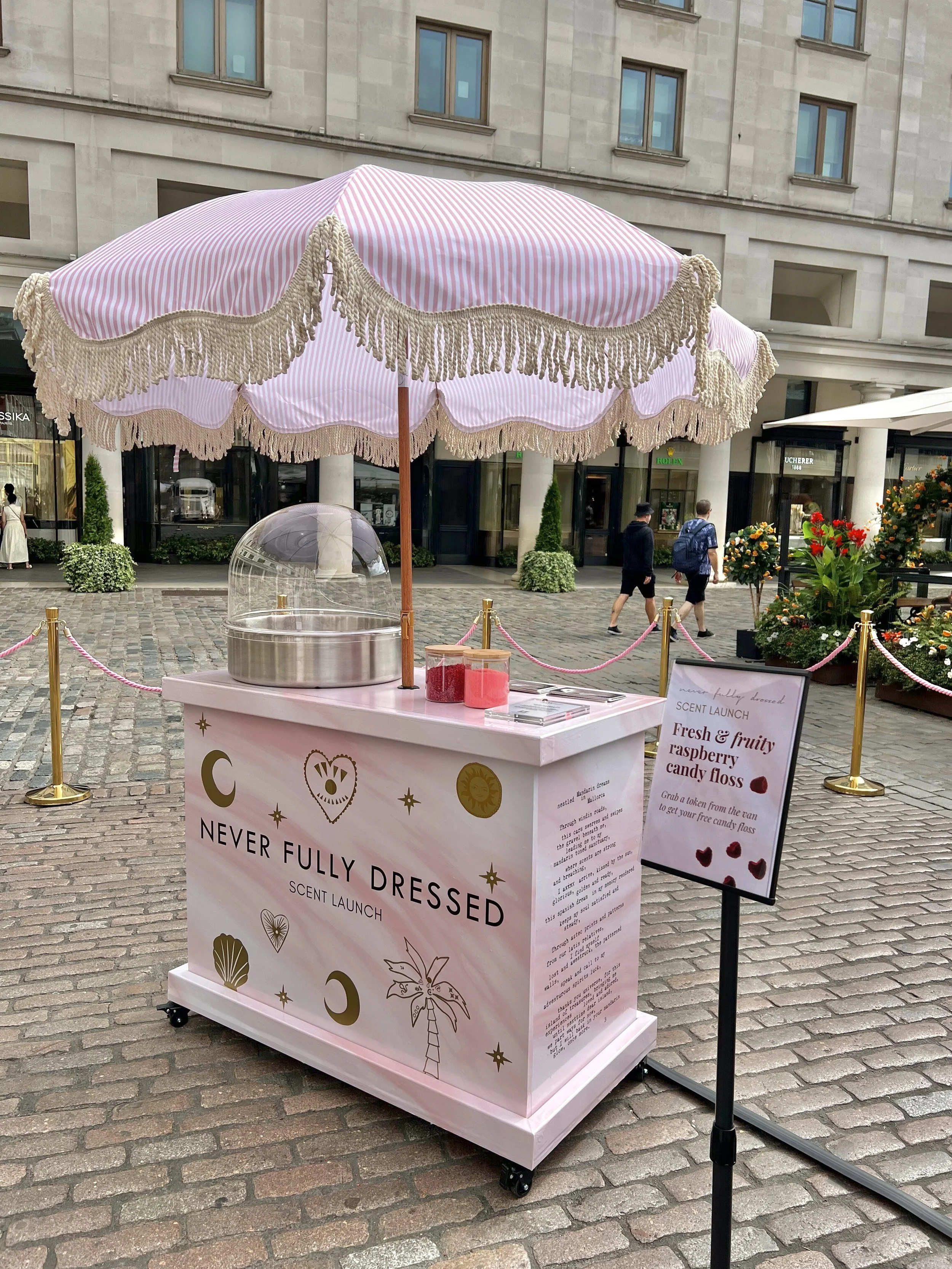 Branded candy floss cart with fringed parasol at Never Fully Dressed fragrance pop-up
