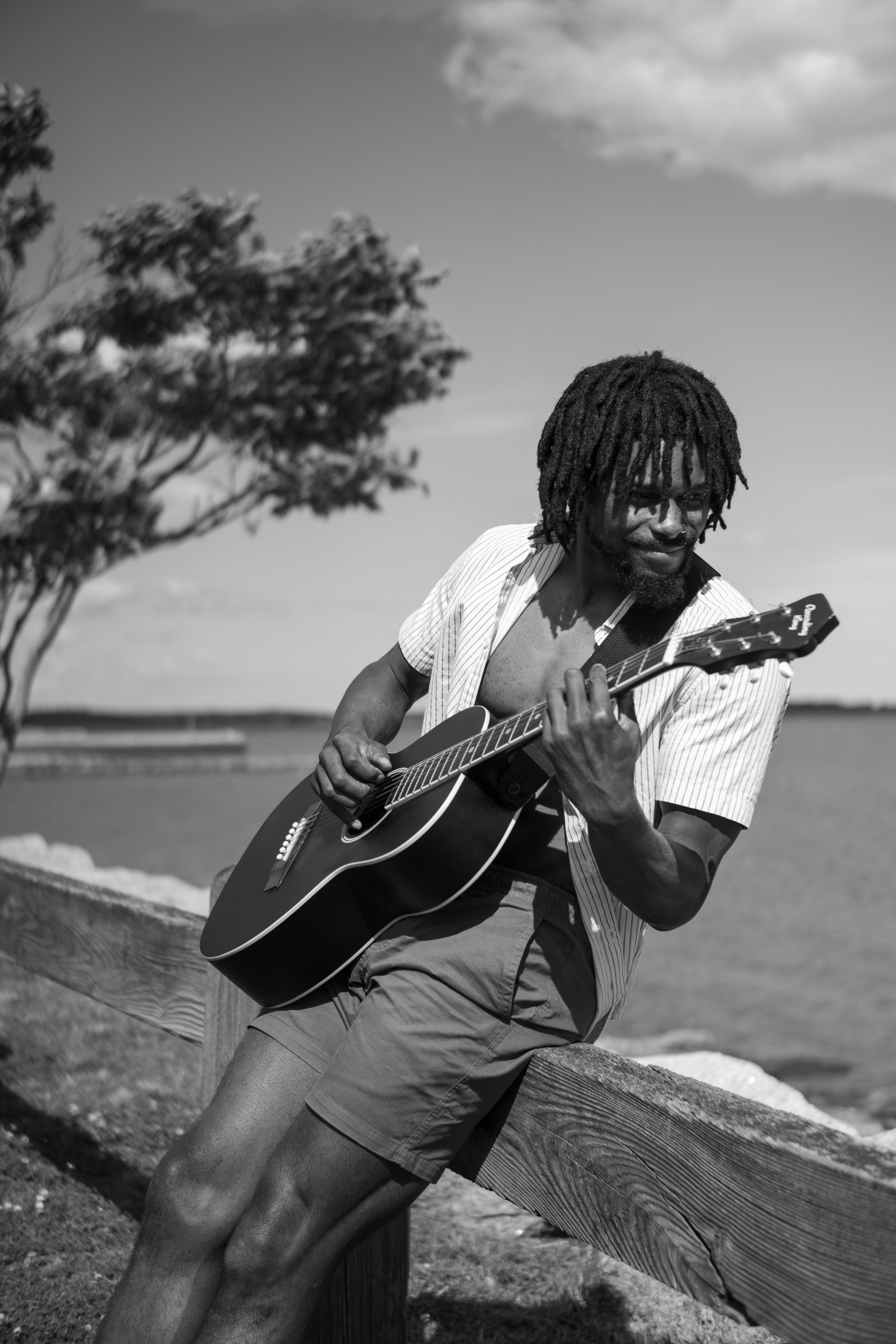Tang Sauce playing guitar in a black and white image by Frankie Rivera