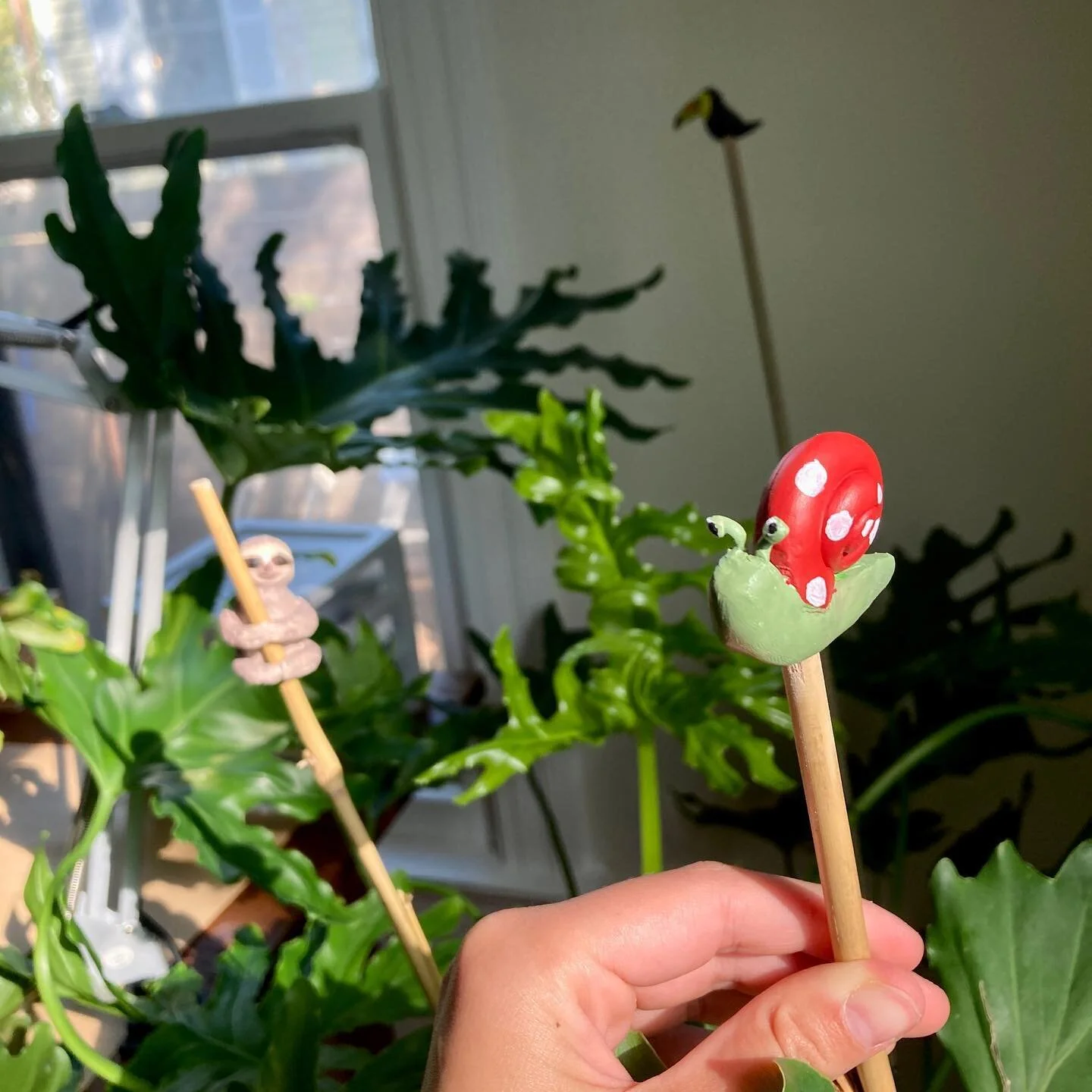 we inherited this big plant that needed some bamboo supports, so made it some friends with oven bake clay and acrylic paint 🦥🦜🐌