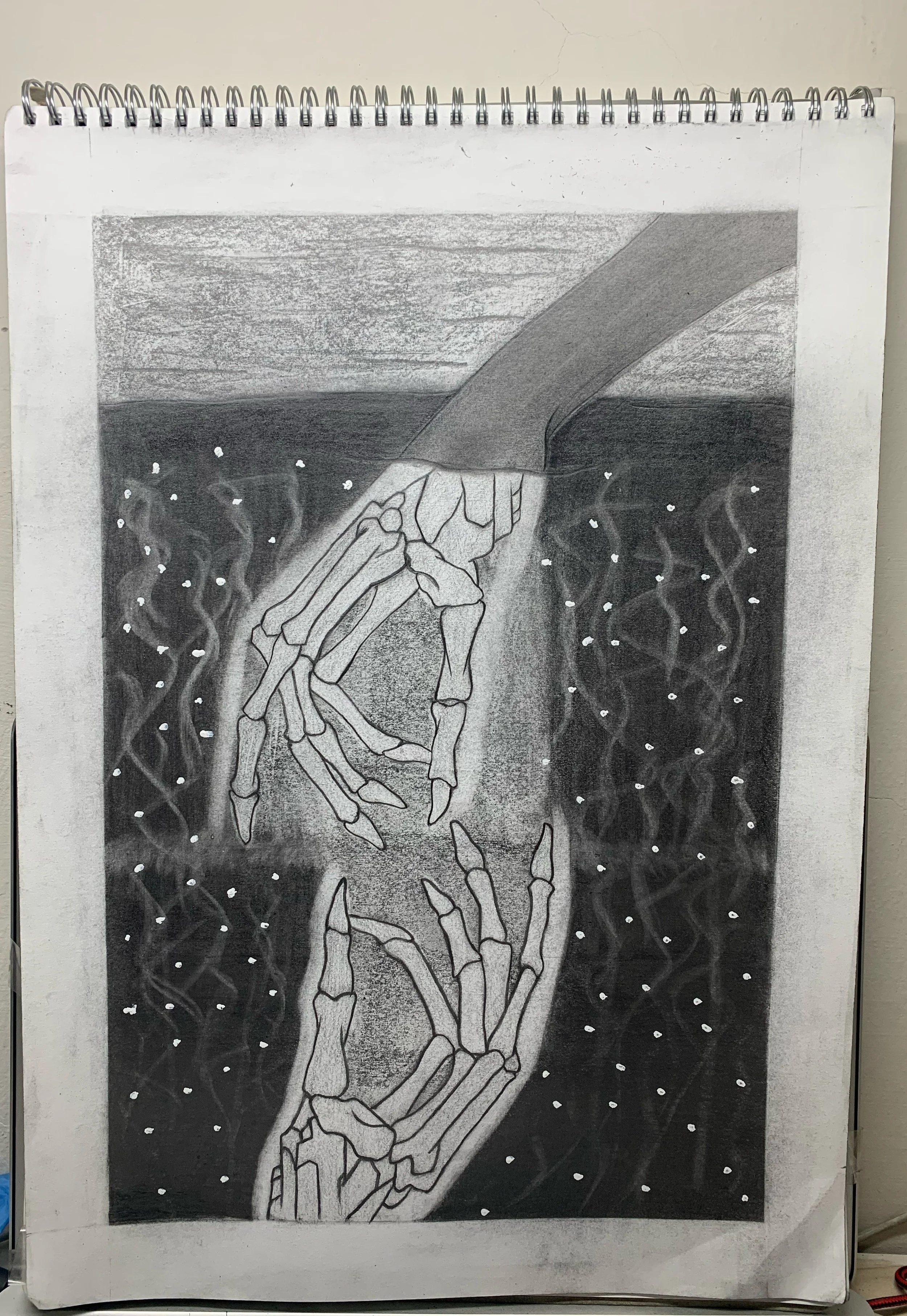 A pencil drawing of two skeletal hands reaching towards each other, one covered by a long sleeve, surrounded by a dark, textured background with white dots and faint swirling patterns.