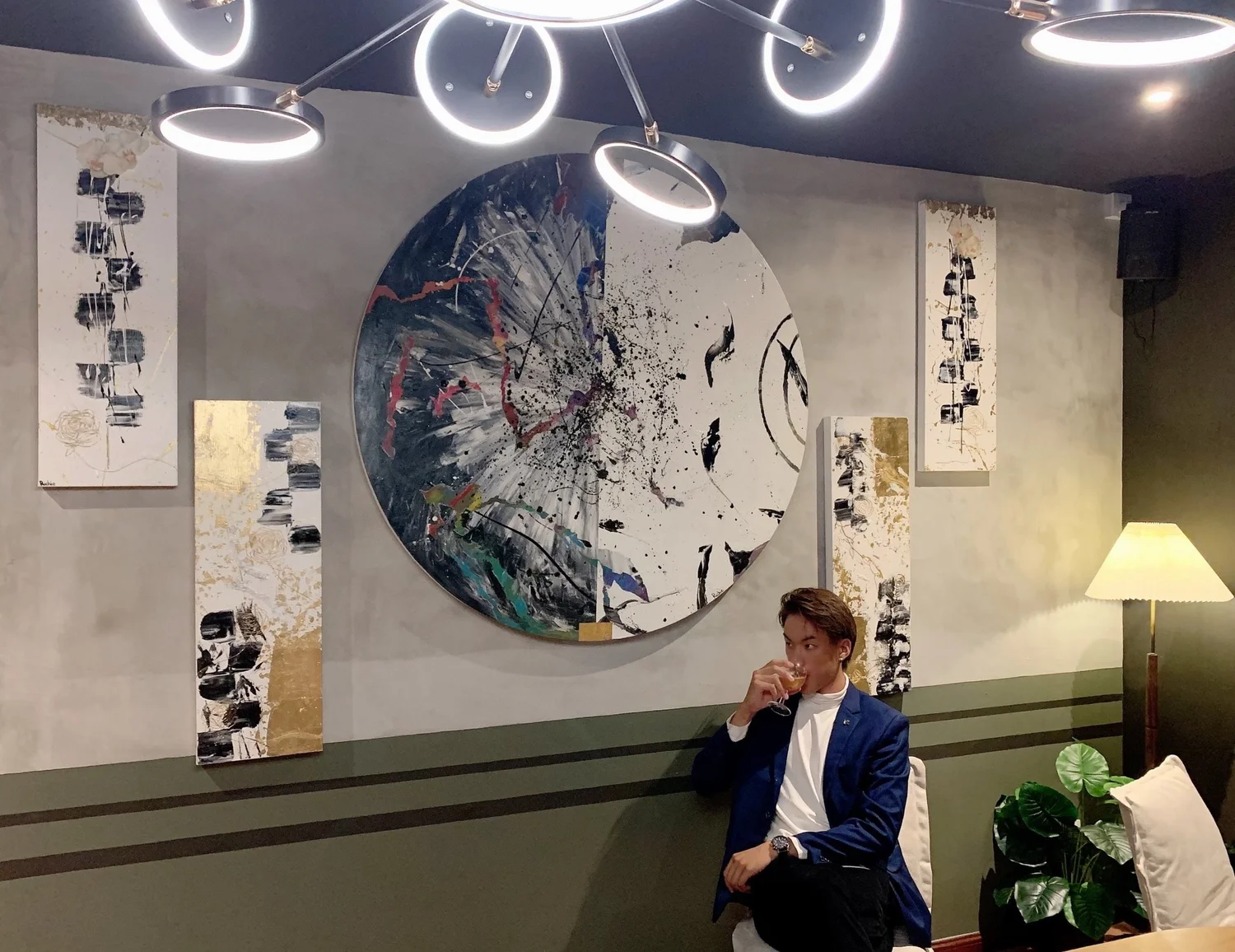 Richie Tan before a large abstract work