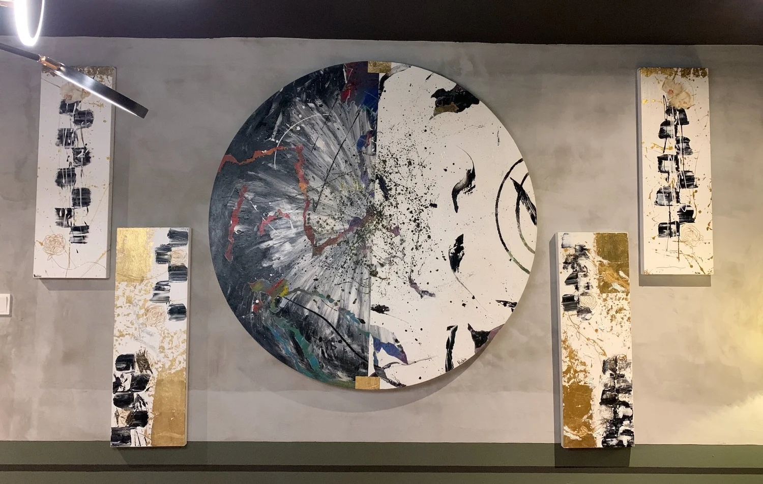 Semicircular abstract piece flanked by four painted panels with black, white and gold accents