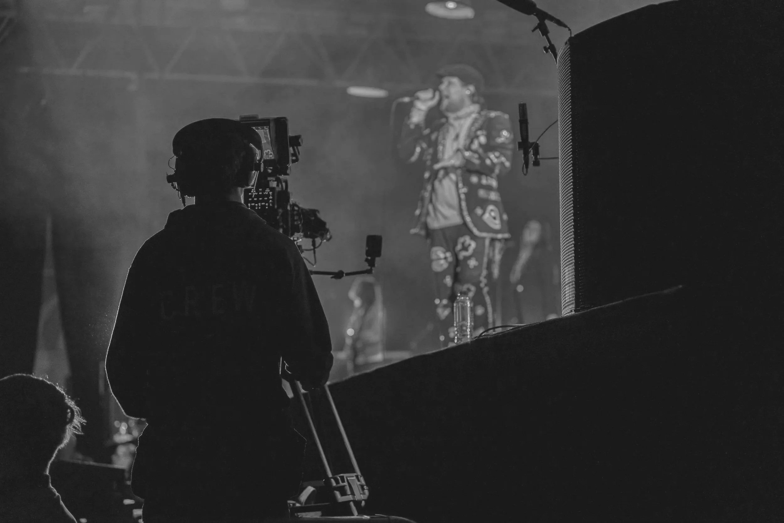 A camera operator filming on a Blackmagic URSA Broadcast G2 camera at a live music event.