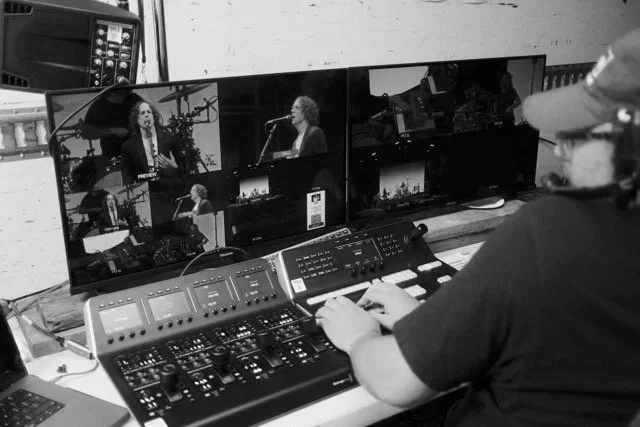 A mixing operator cutting between shots on a multi-camera music festival event.