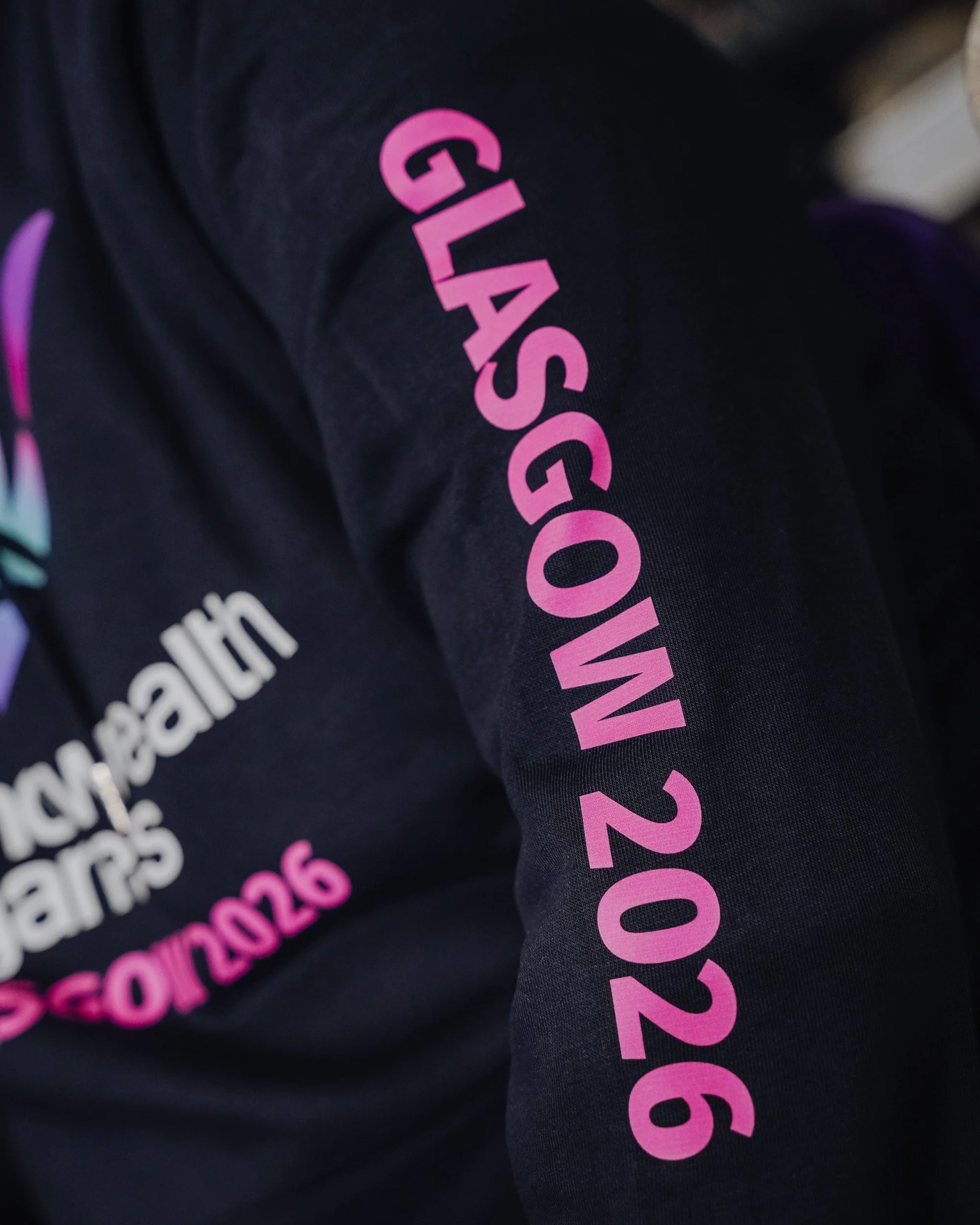 Close-up of a black shirt with pink and white text referencing the 2026 World Cup.