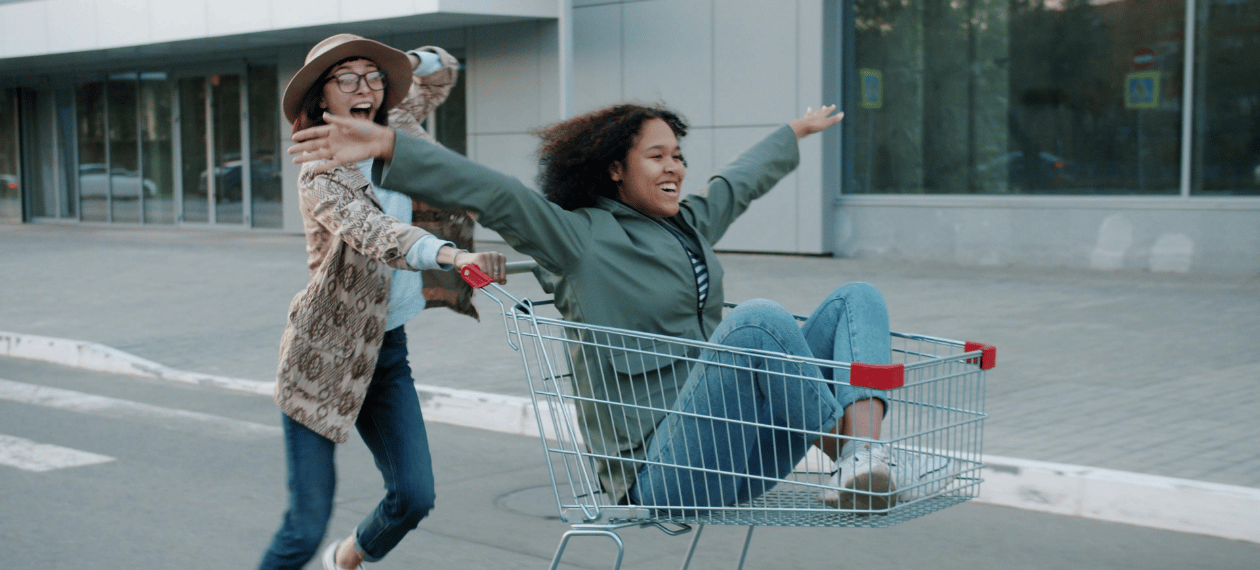Friends having fun with a shopping cart representing the online buying experience
