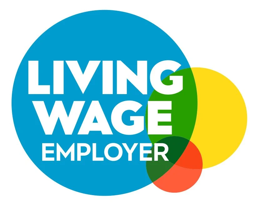 Text reading "Living Wage Employer" inside overlapping colorful circles of blue, green, yellow, and red.