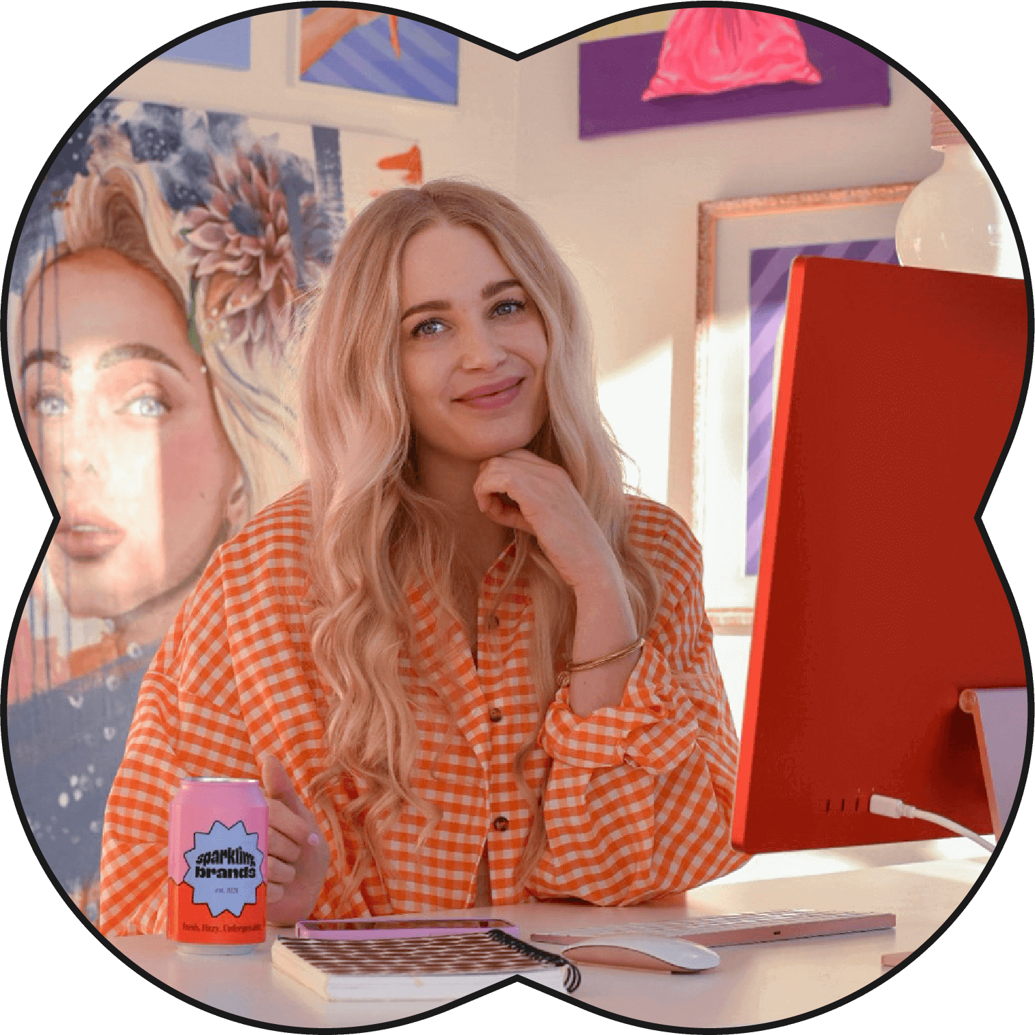 Suunnittelija oranssissa ruutupaidassa työpisteellä