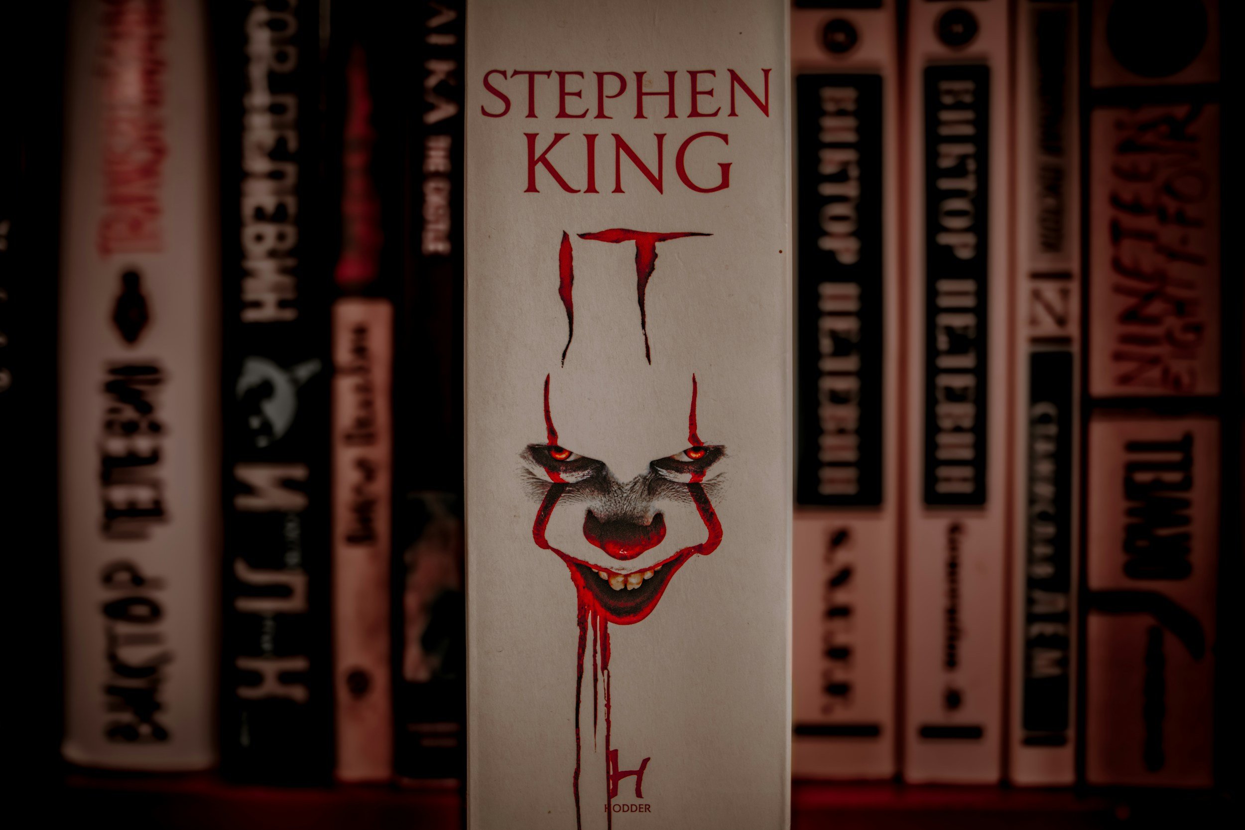Stephen King books on a shelf, with a copy of It featuring Pennywise at the centre.