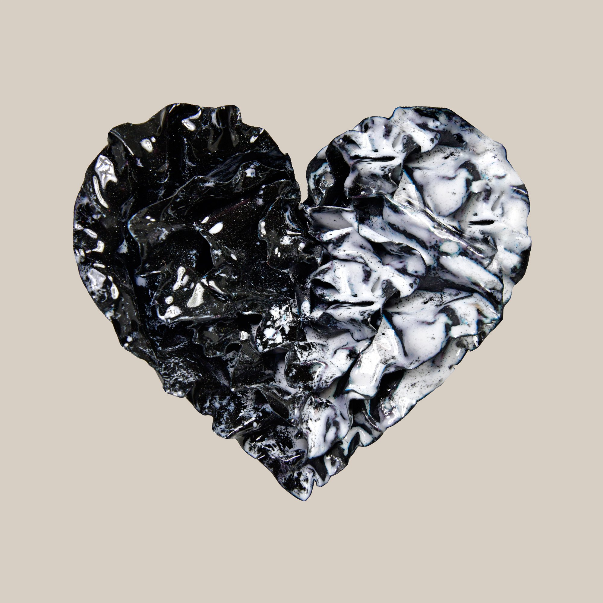 Black and white enamel heart sculpture with textured folds and a split design, part of Sherry Been’s Black Collection