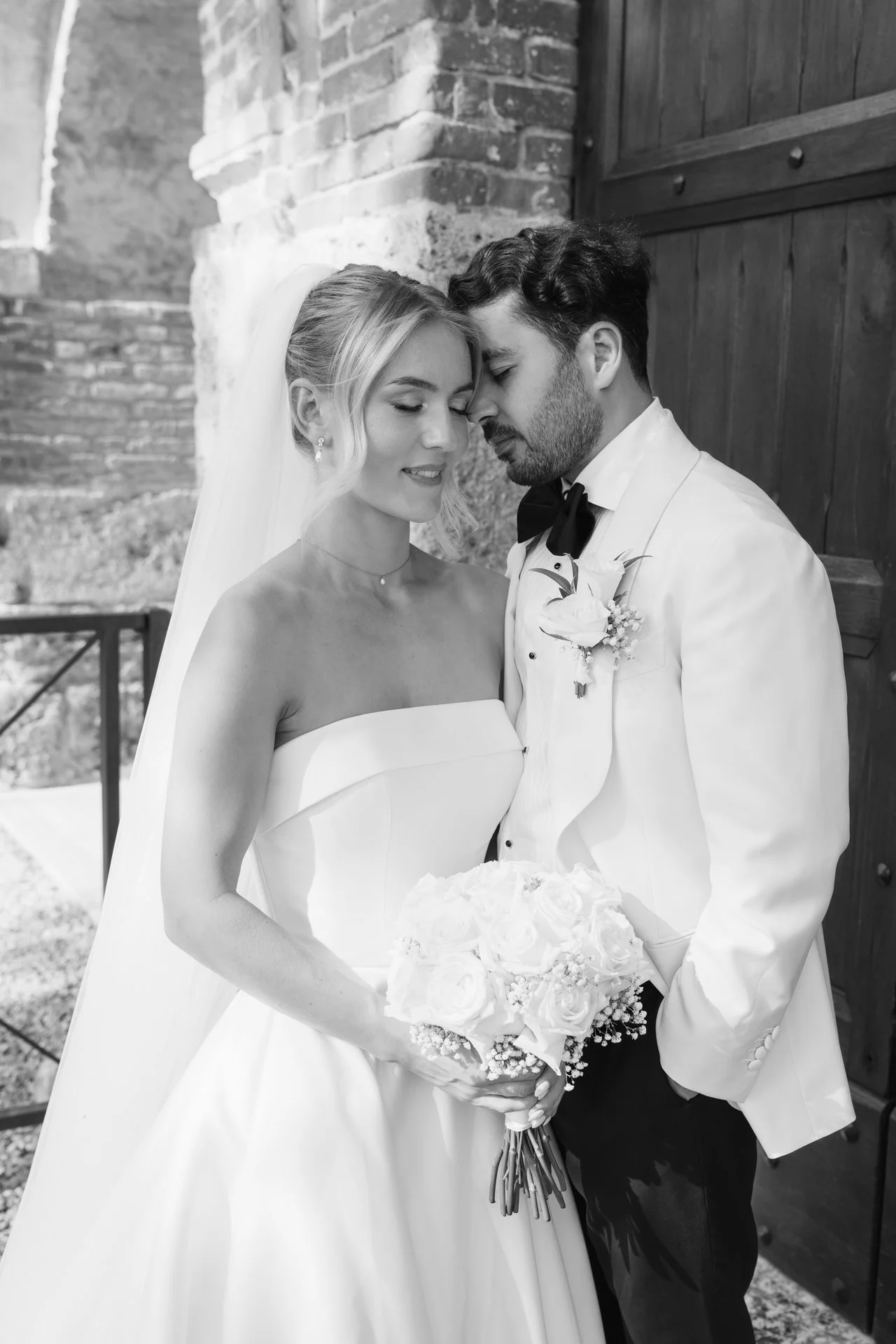 Destination wedding couple posing inside San Galgano Abbey in Tuscany.