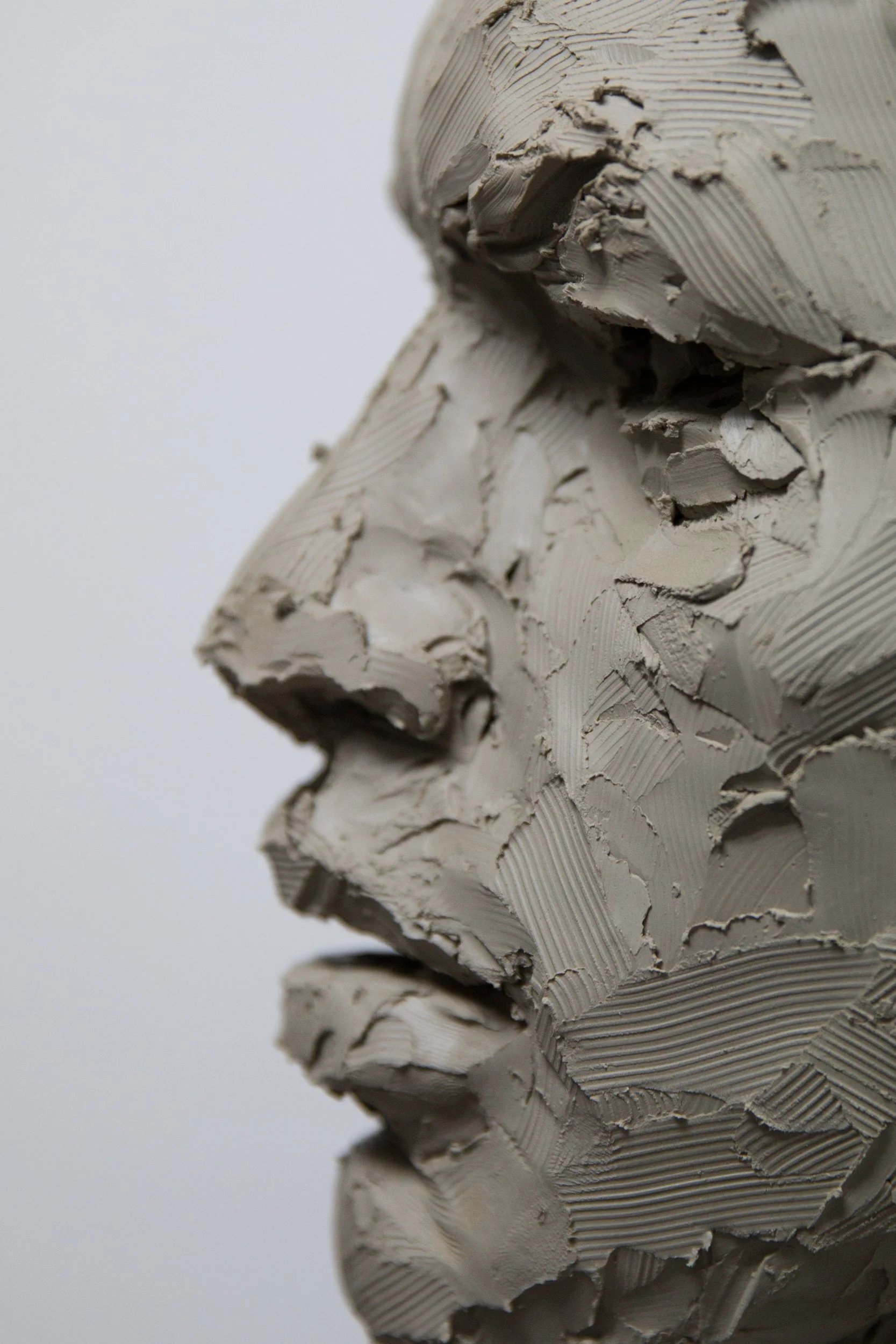 Close-up view of a crane with a mitered corner, with textured and uneven layers of fresh plaster on a wall.