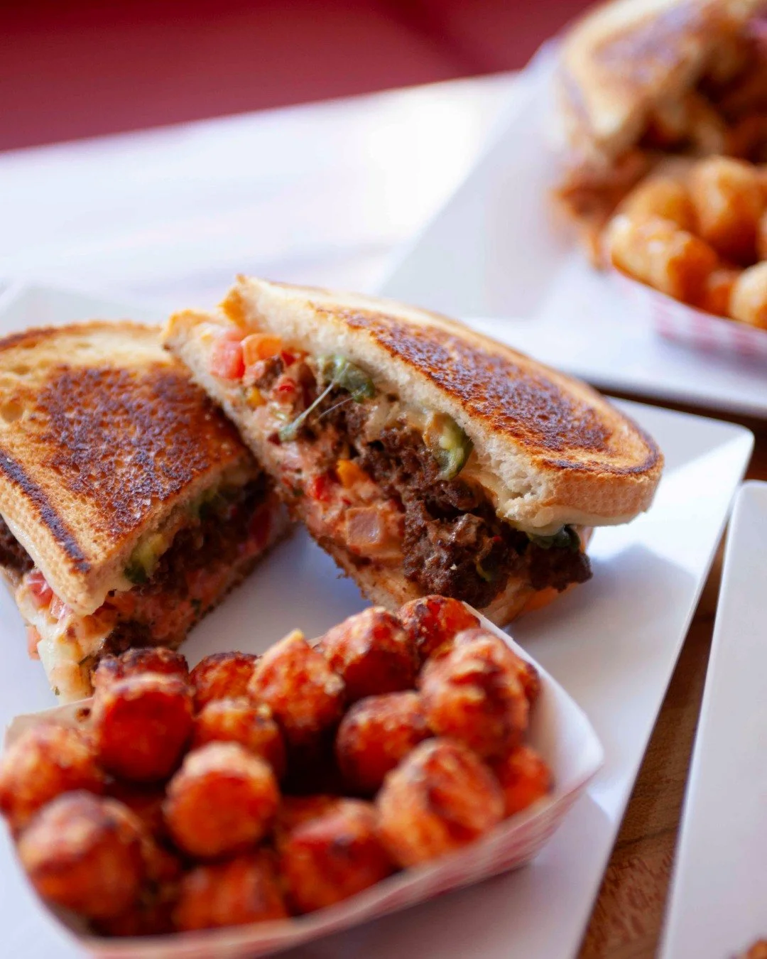 Go ahead, take a peek inside... melty cheese, savory fillings, perfectly grilled bread, and crispy sweet potato tots on the side 🥪 🥔 Pure comfort food bliss. Who's hungry?

#Gourmeltz #GrilledCheeseUpgrade #TaterTotLife