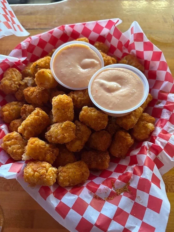 When the tots show up this big&hellip; you know it&rsquo;s a good day.
Pile of golden goodness + two dipping sauces. Share or don&rsquo;t. We won&rsquo;t judge.