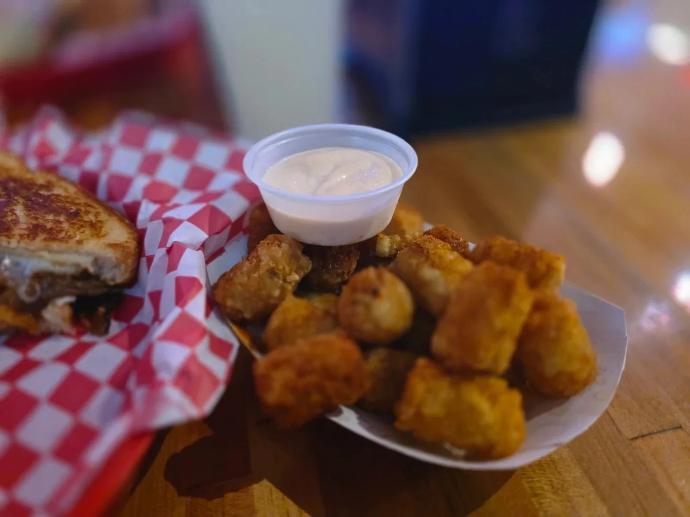 Tots + sauce + melt = happiness. 🙂
A melt masterpiece and golden crispy tots and creamy dip on the side.
This is how we do comfort food.