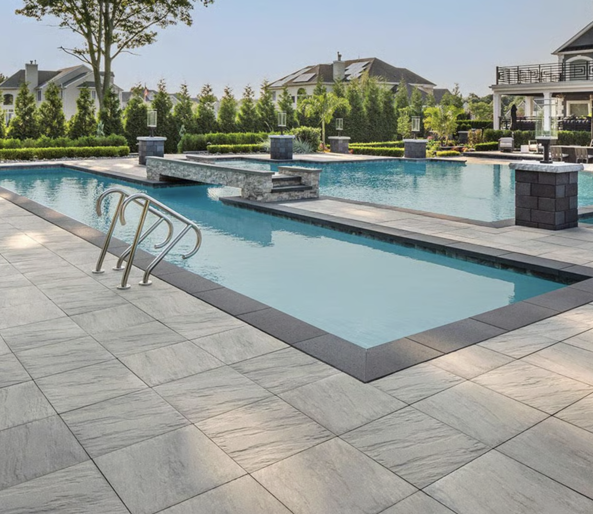 Linear swimming pool with wide stone pavers and clean-edge design showcasing modern pool landscaping in Toronto.