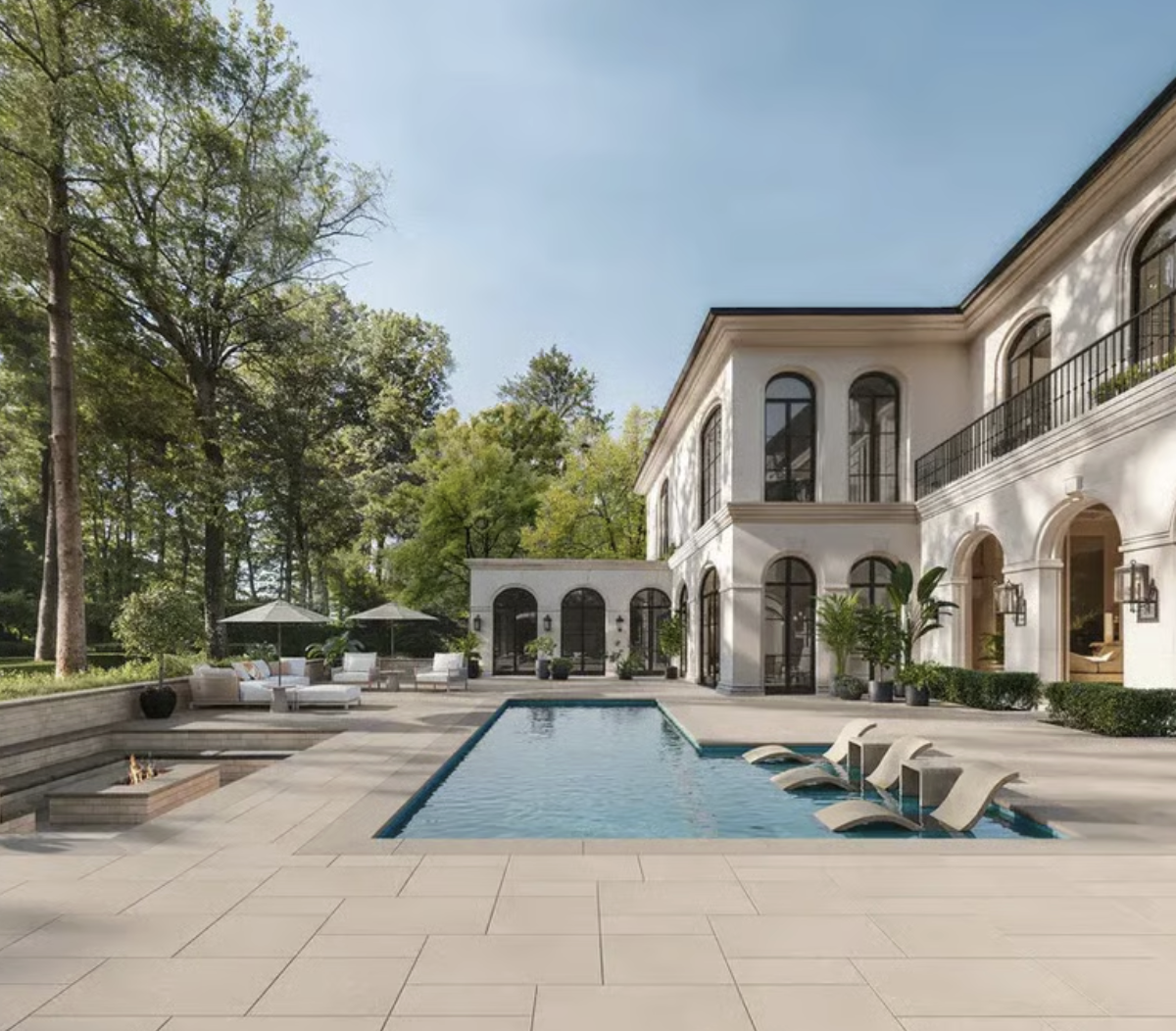 Elegant residential pool with stone patio, lounge seating, and refined outdoor architecture in a high-end Toronto backyard.