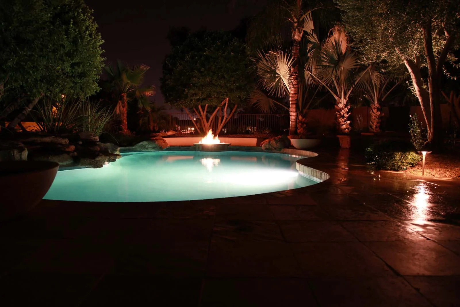 Luxury backyard pool design with premium stone pavers, symmetrical planting beds, and integrated landscape lighting for an upscale Toronto outdoor space.