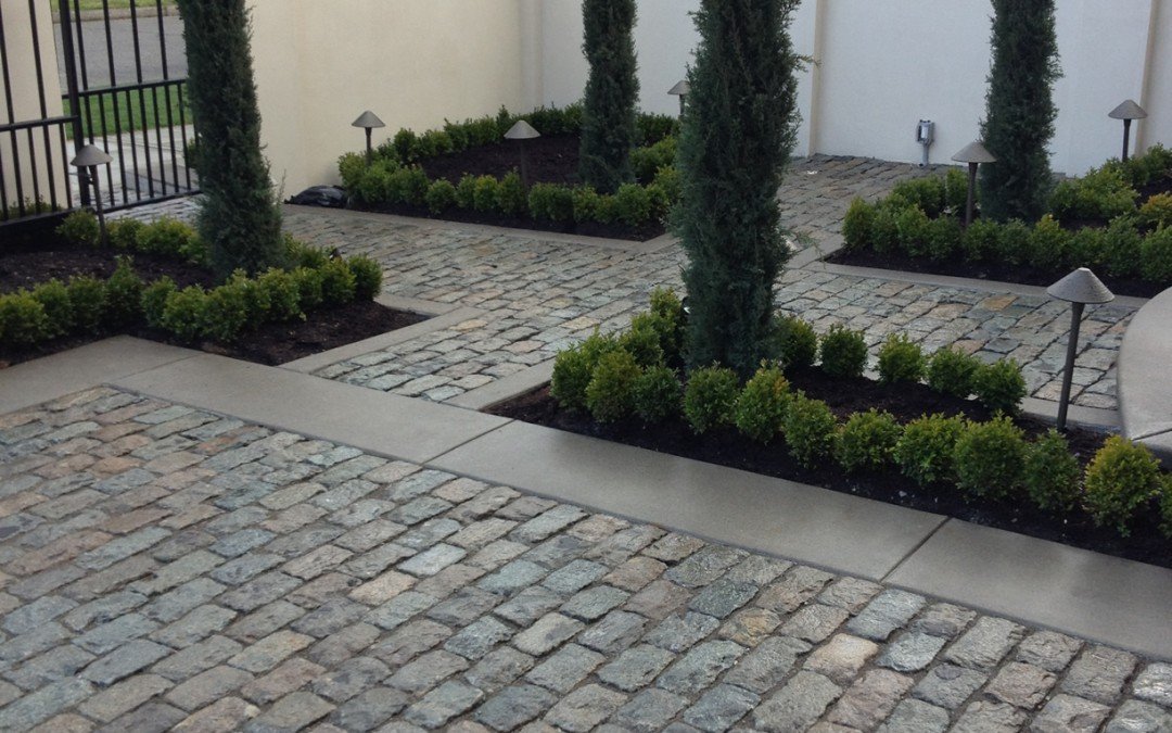 Cobblestone garden walkway with clean edging and structured planting beds