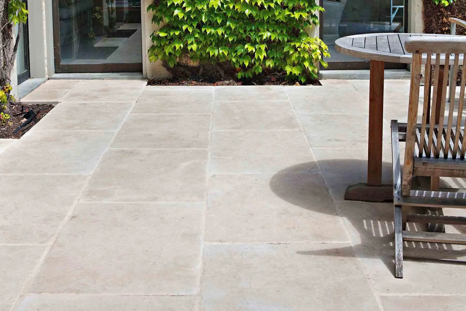Smooth natural stone patio surface with clean joints in contemporary backyard design.