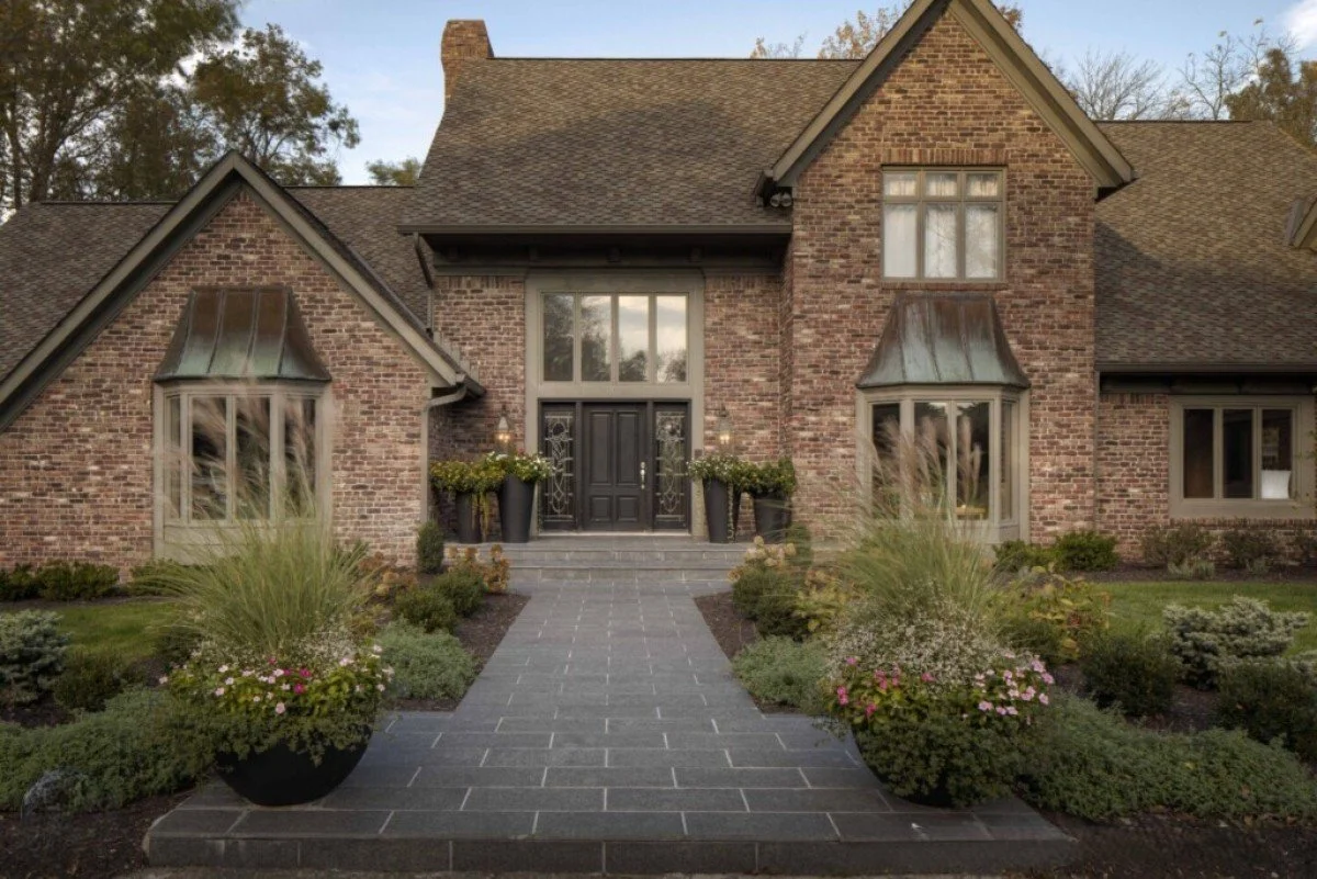 Formal front entrance with stone walkway and classic home landscaping