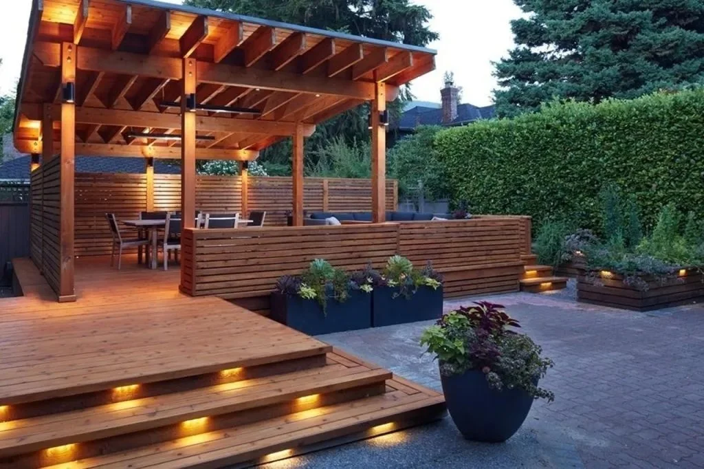 Wood deck with custom pergola, built-in planter boxes, and step lighting for a modern backyard retreat.
