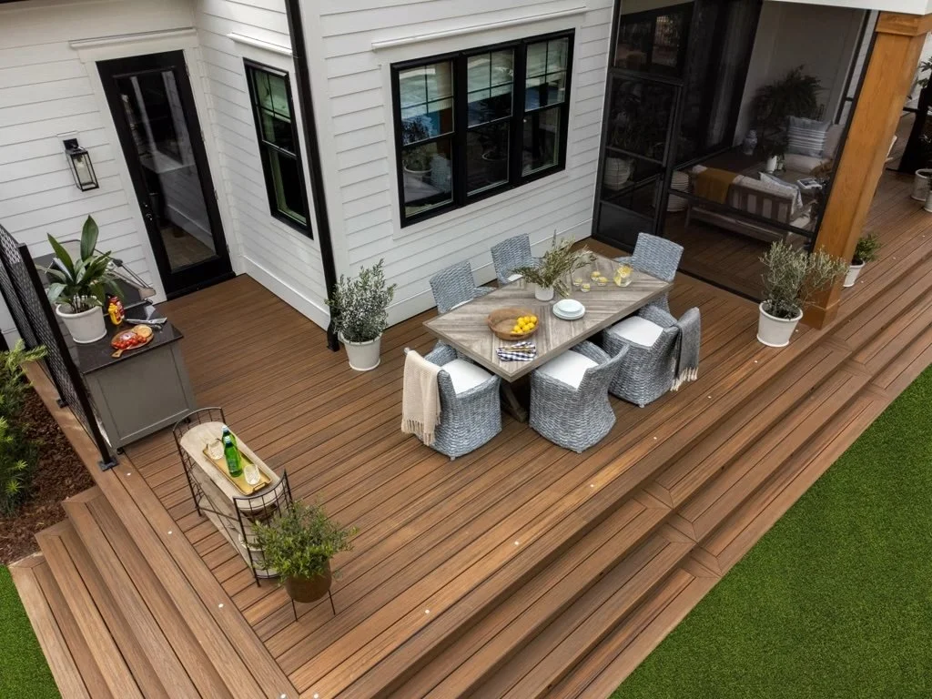 Small elevated backyard deck with outdoor dining set, white siding, and cozy corner seating layout.