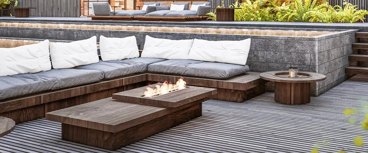 Luxury wood deck seating area with built-in sectional cushions and modern linear fire feature.