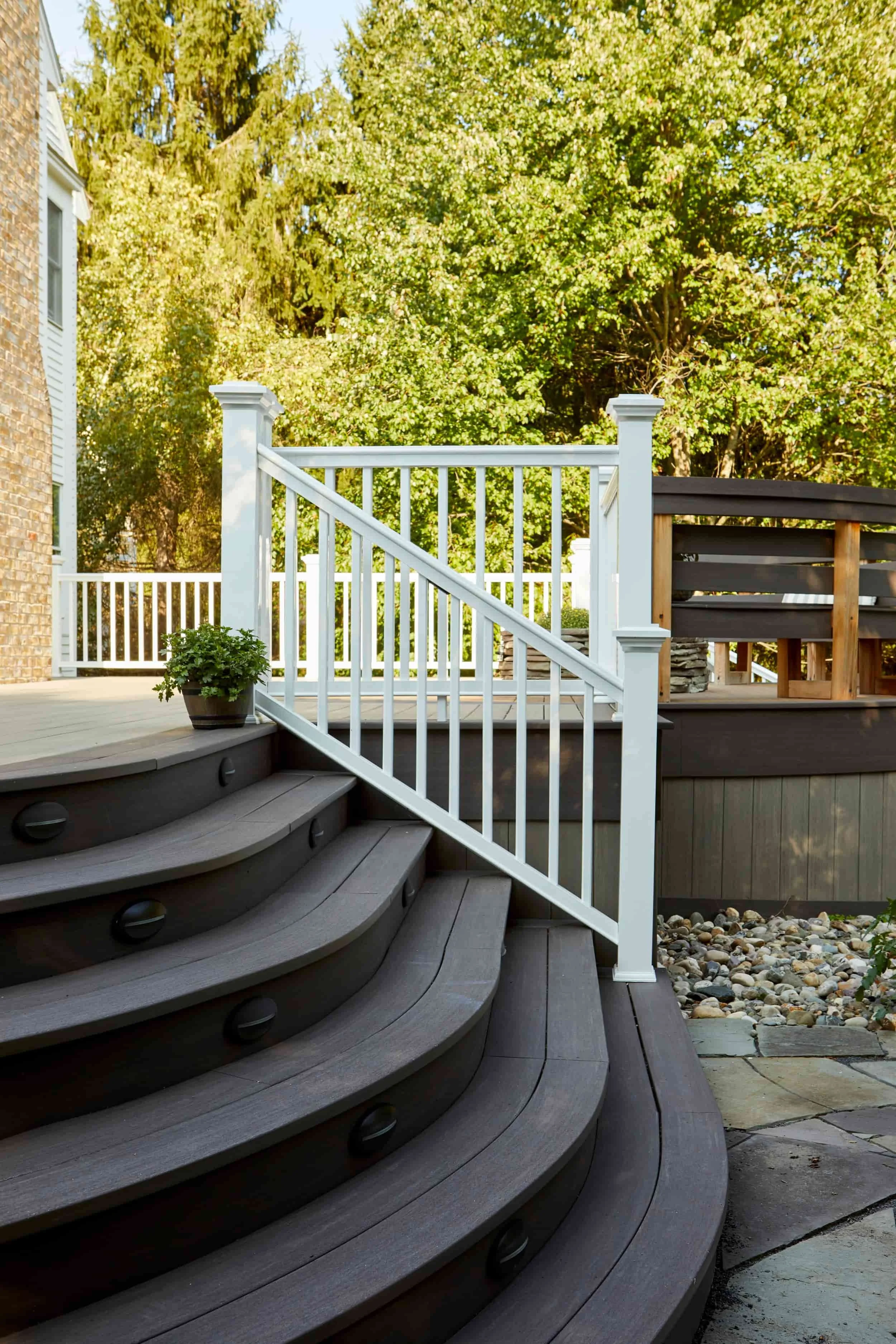 Modern composite deck staircase with metal cable railing system on home exterior