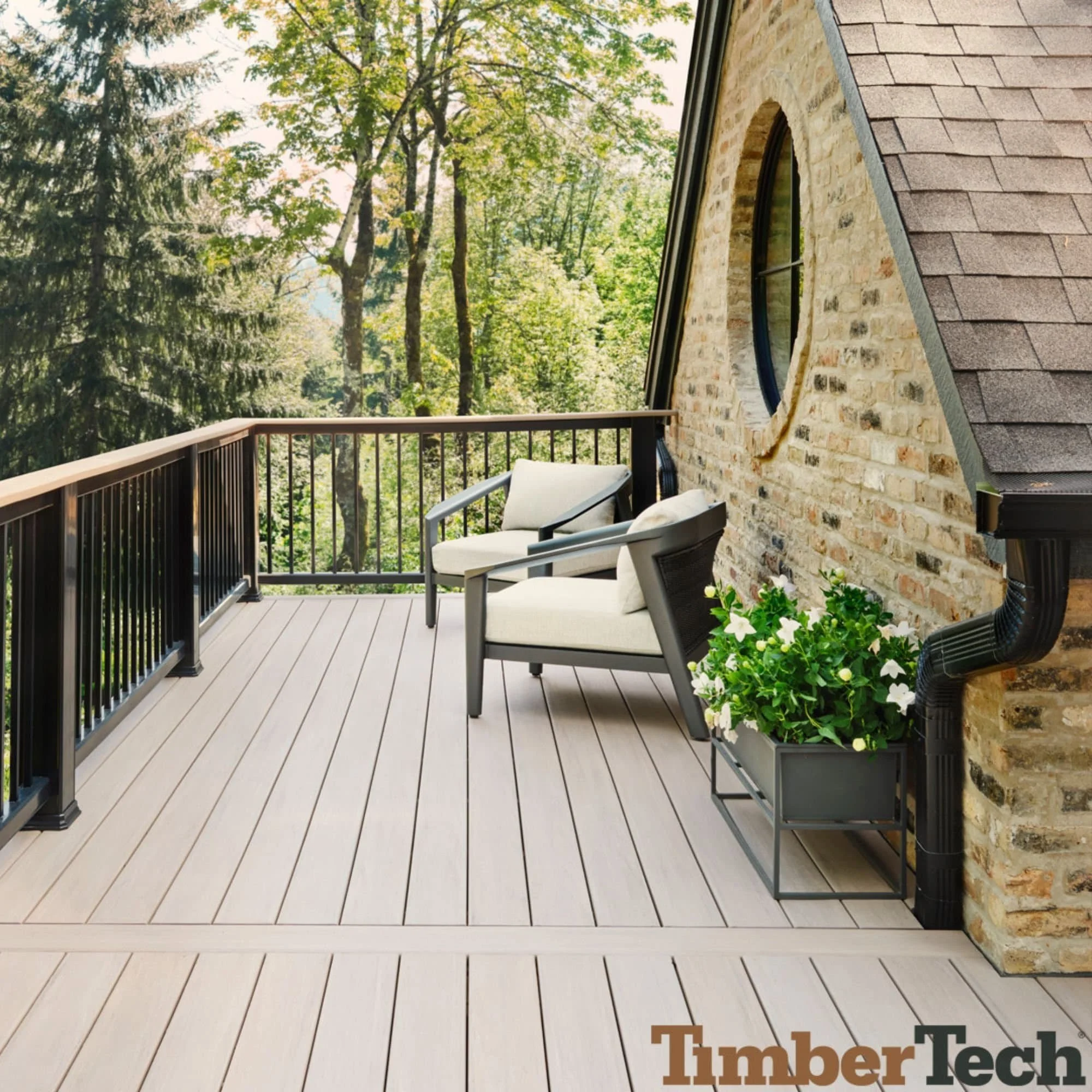 TimberTech deck with light gray composite boards and outdoor seating area next to stone wall